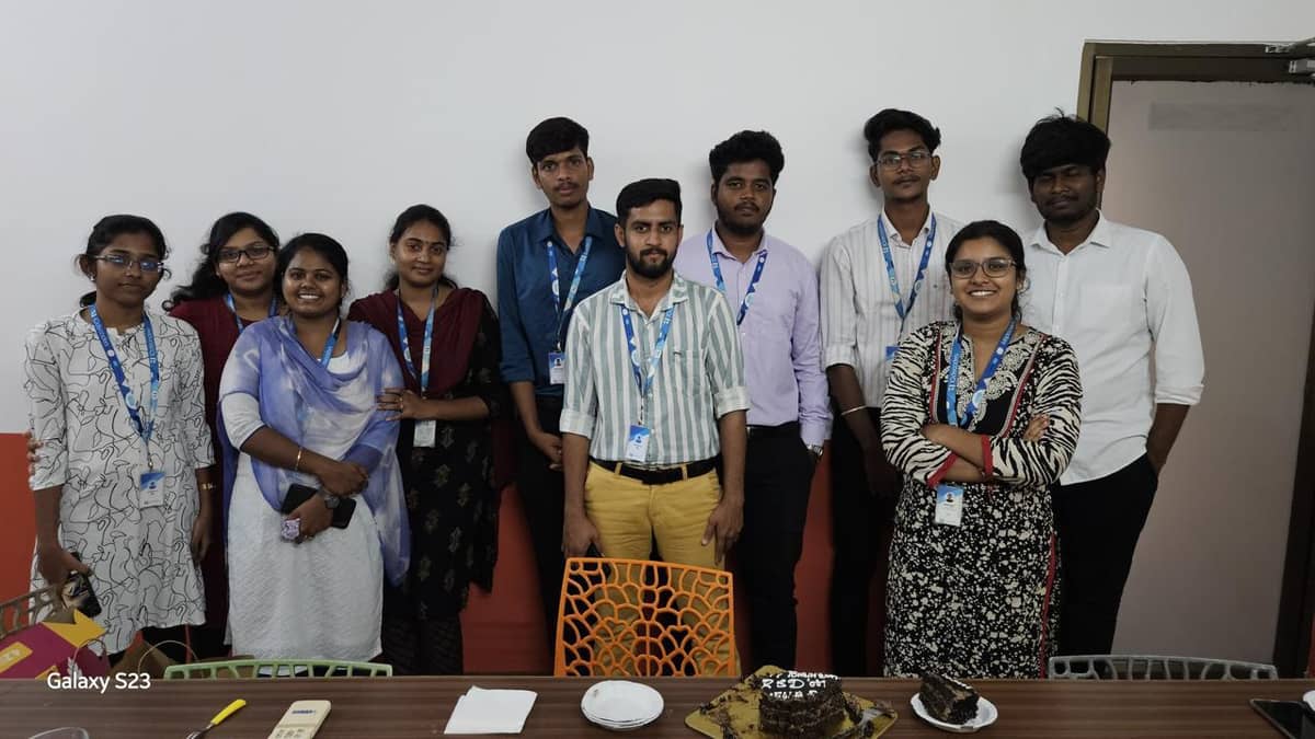 Members of the 10decoders team gathered around a table with a celebration cake