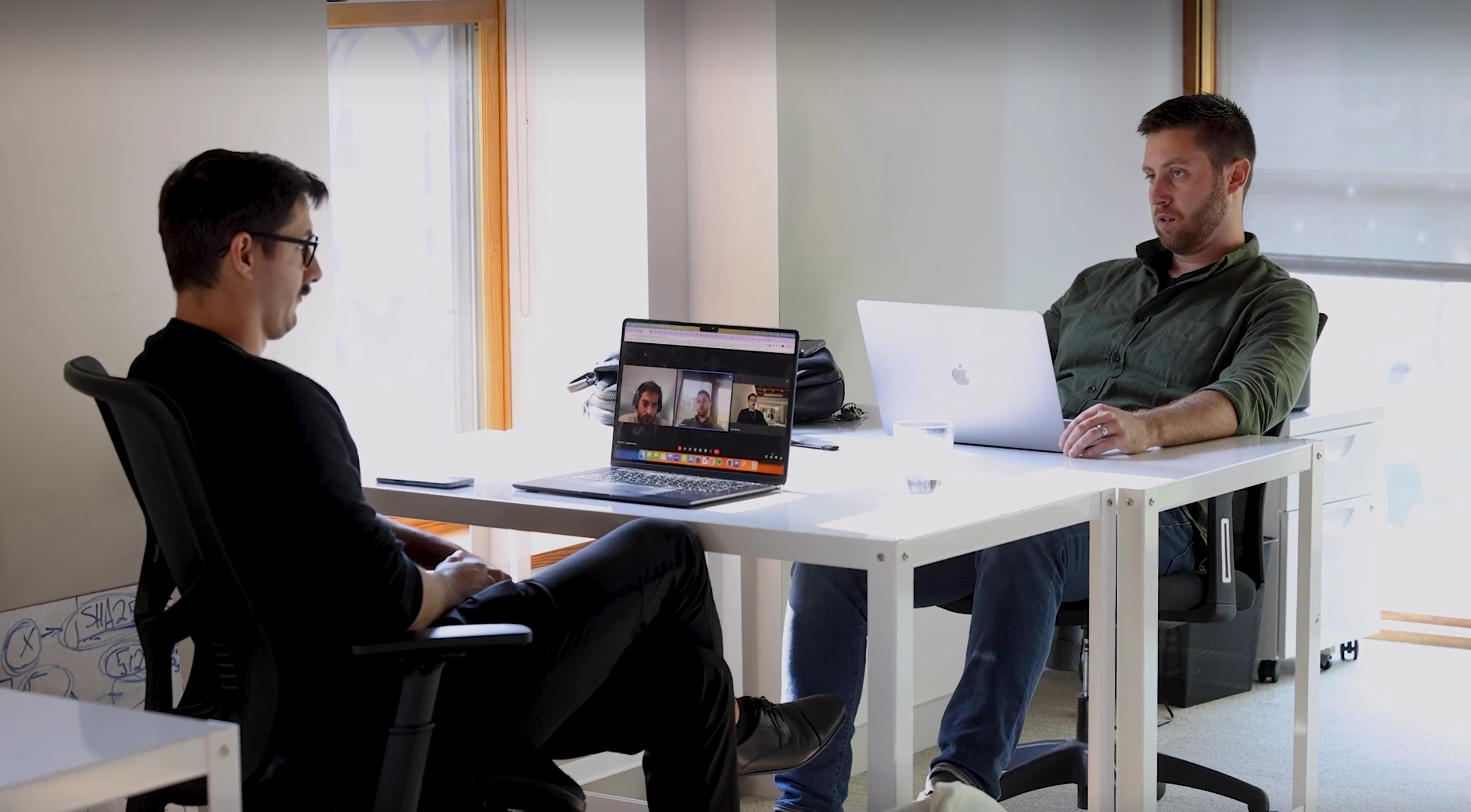 Two people working across a shared table with laptops in the workspace image published by Venture Central