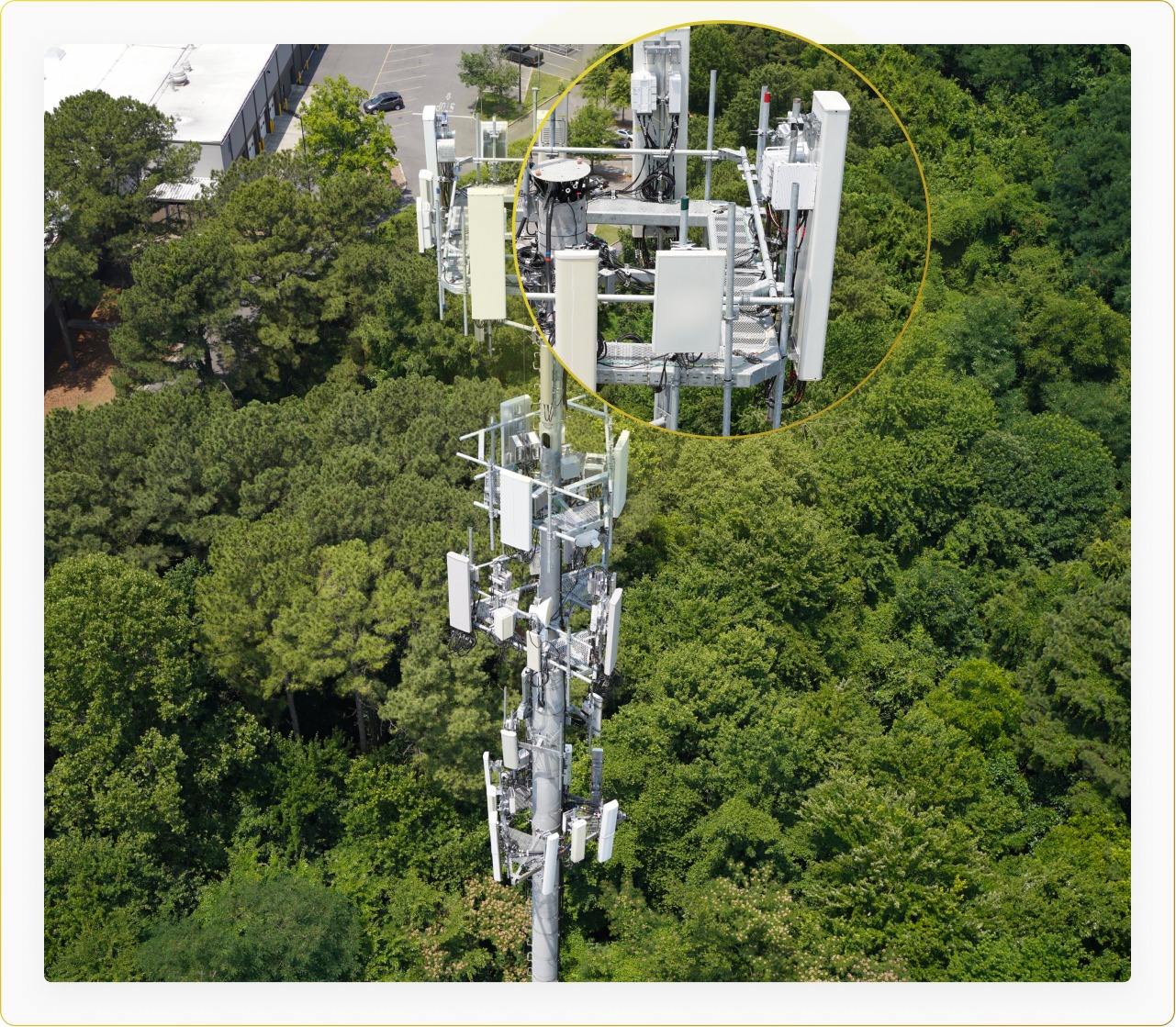 Drone-captured aerial view of a cellular tower in a forest with an inset showing antenna detail