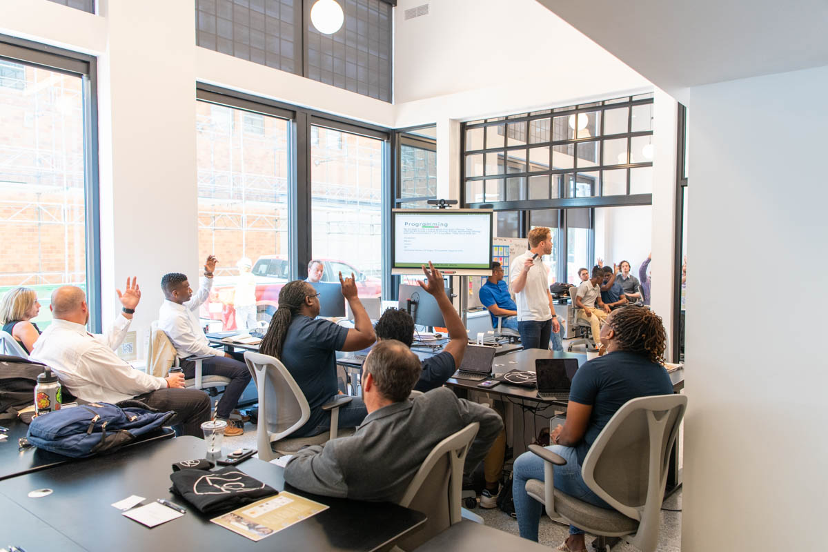 Founders and mentors raise their hands during a workshop at 757 Collab in Norfolk