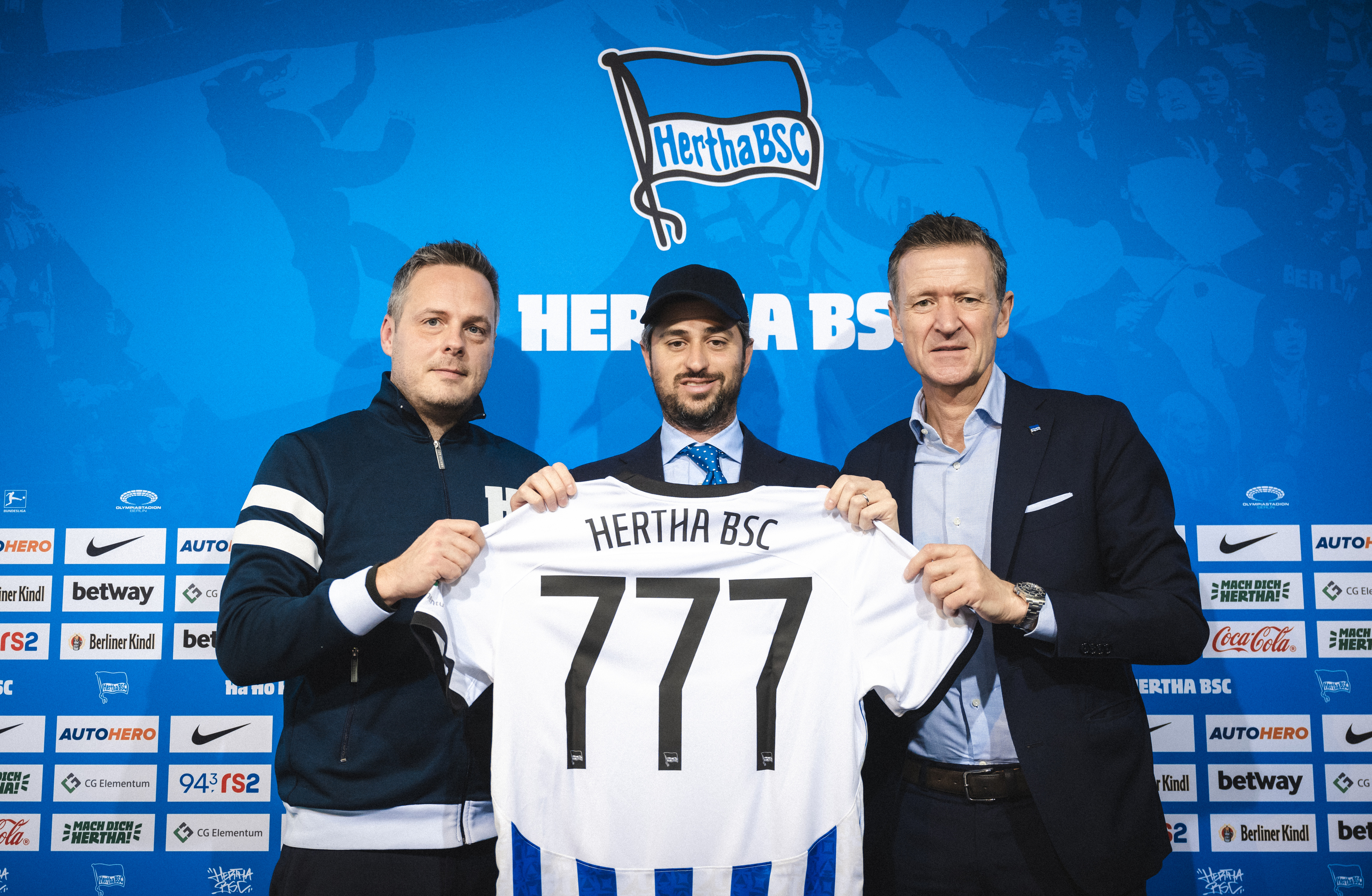 Kay Bernstein, Josh Wander and Thomas Herrich hold a Hertha BSC shirt bearing the number 777 at the March 2023 partnership presentation.