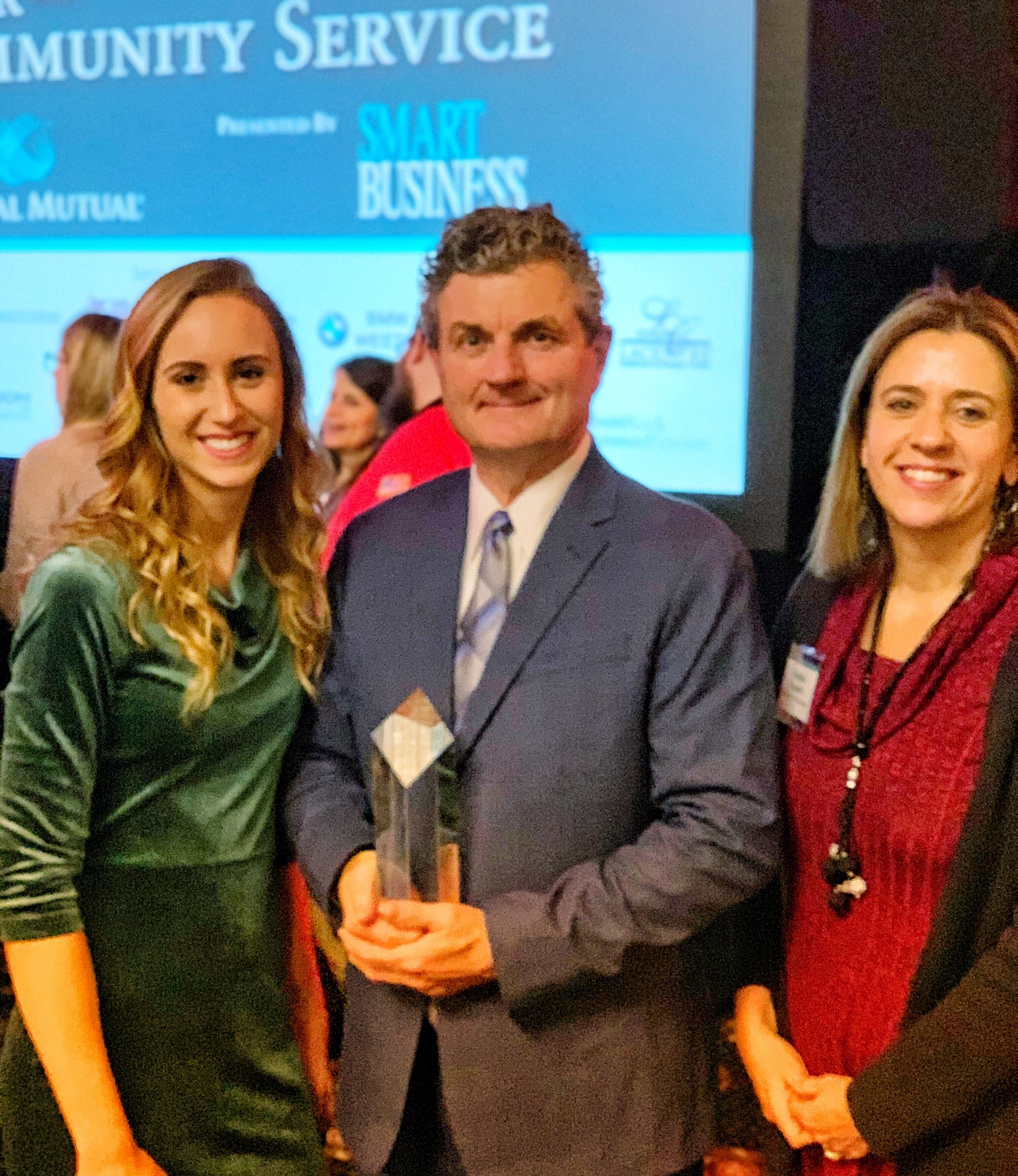 Bethany Friedrichsen, Ray Dalton holding an award, and Barbara Campbell at a community service event