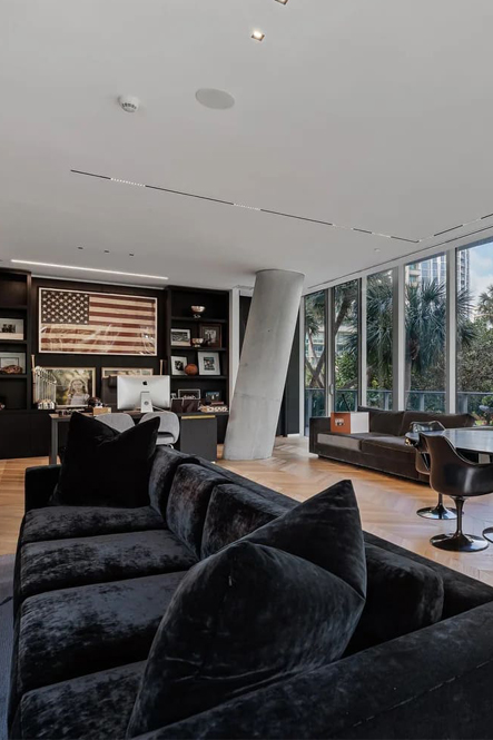 A-Rod Corp office with dark seating, floor-to-ceiling windows and memorabilia behind the desk