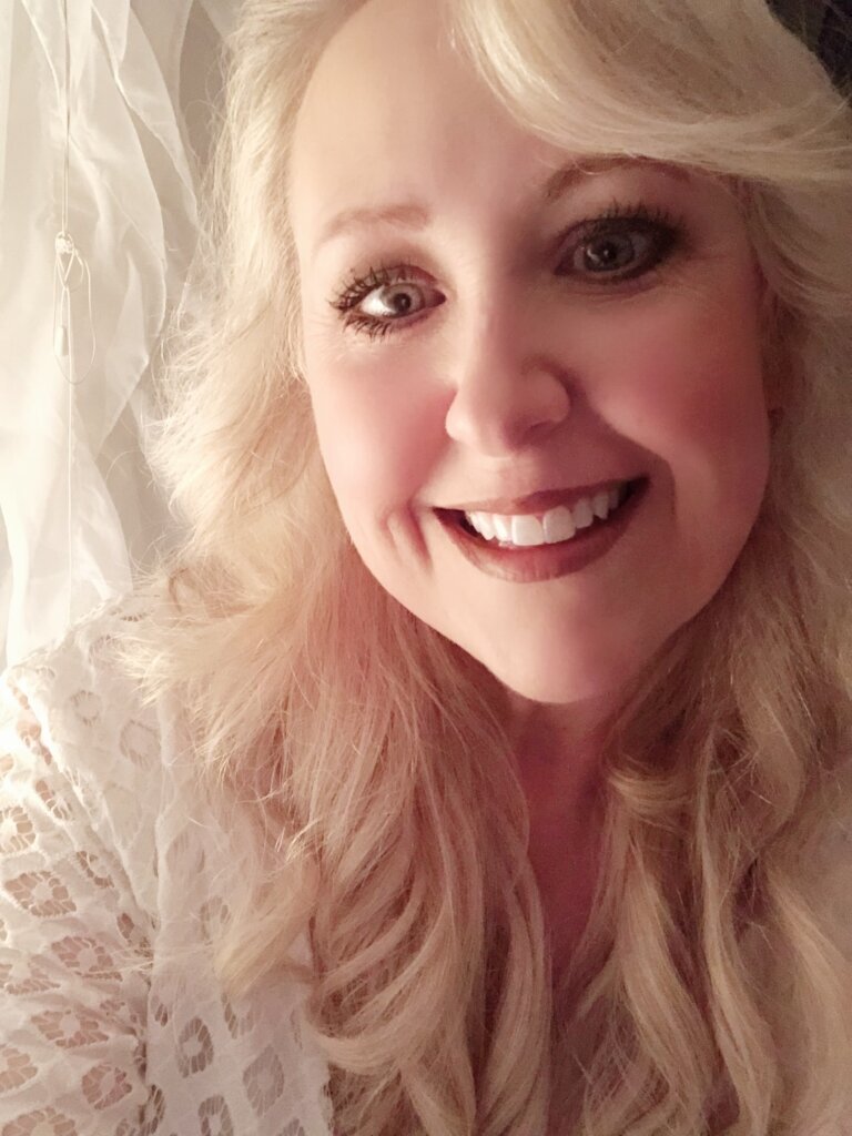 Sharyn Scully, owner of A Touch of Color, smiling in the salon