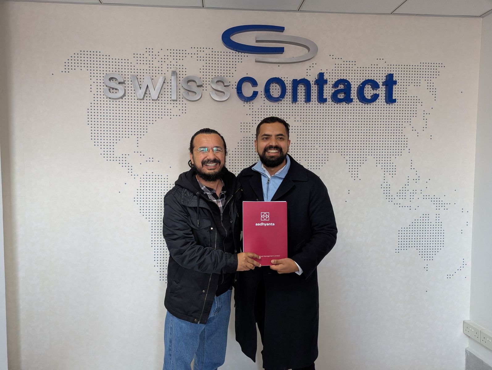 Representatives of DV Excellus and Aadhyanta holding an investment document at Swisscontact