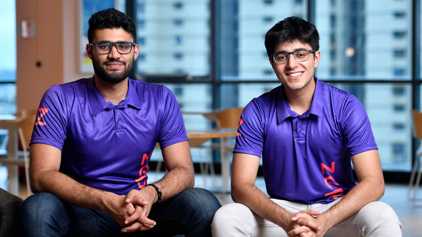 Kaivalya Vohra, left, and Aadit Palicha, right, seated in Zepto shirts