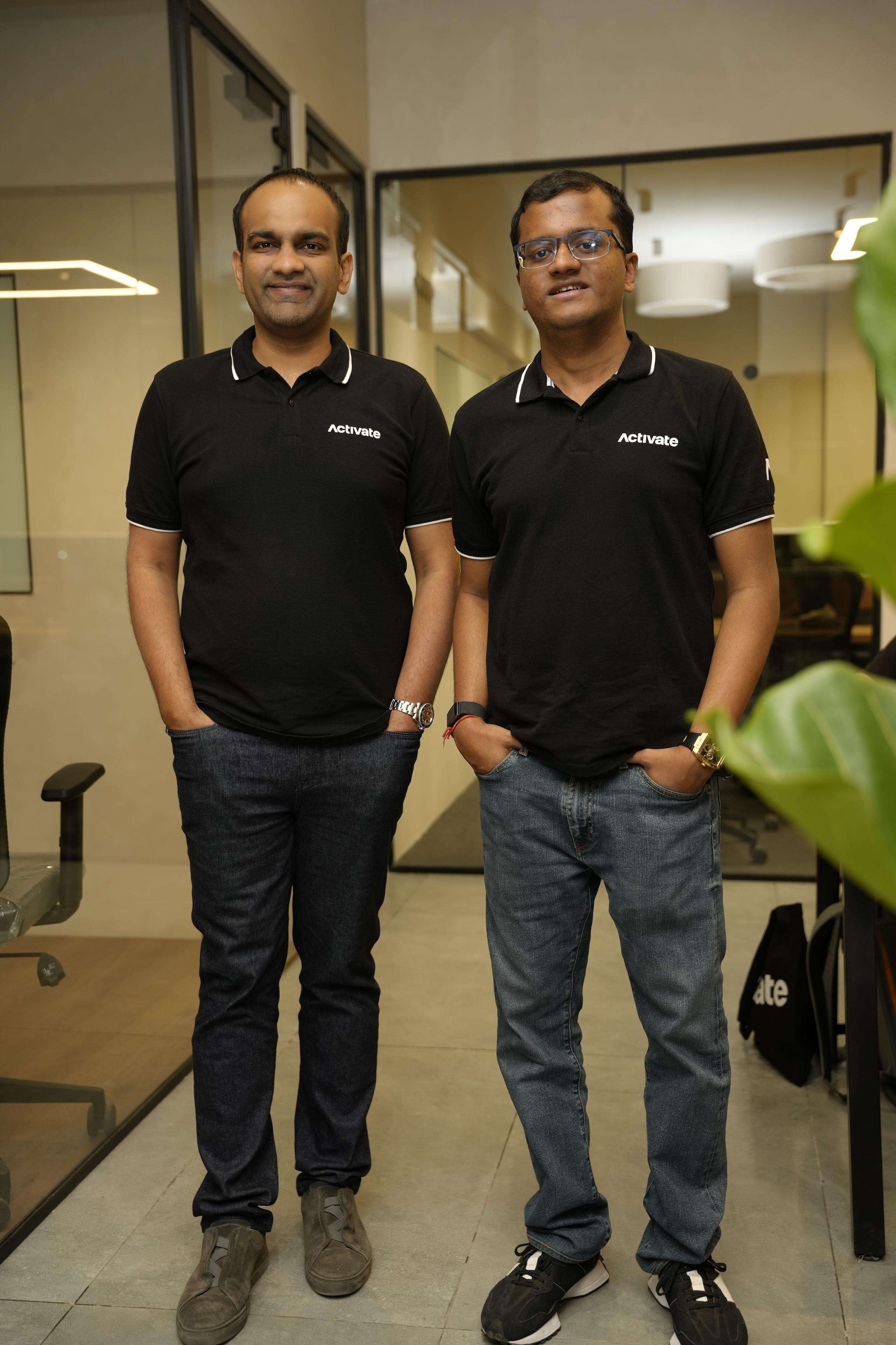 Aakrit Vaish, left, and Pratyush Choudhury standing together in an office wearing Activate polo shirts