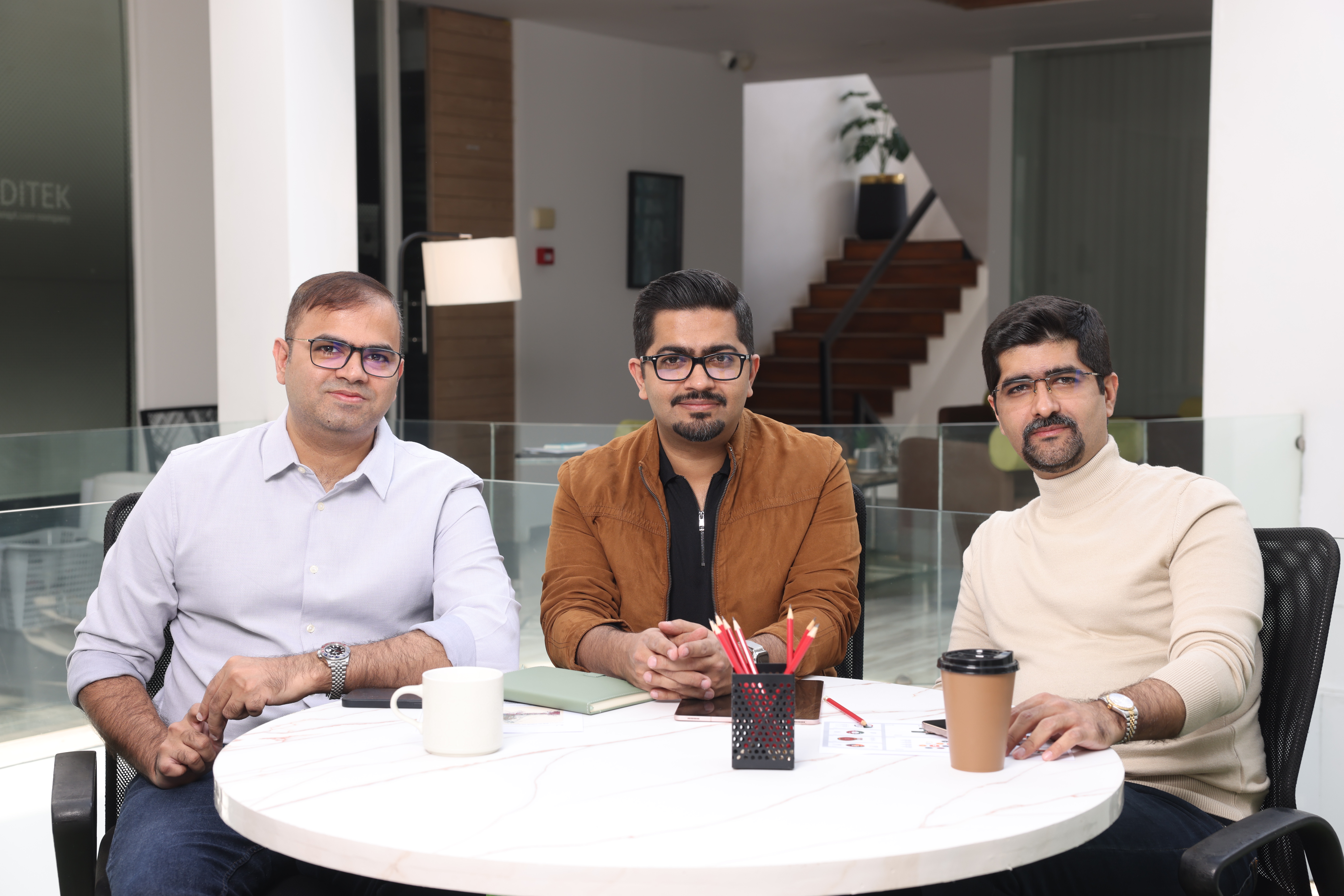 Aaqib Gadit, Umair Gadit and Uzair Gadit seated together around a table