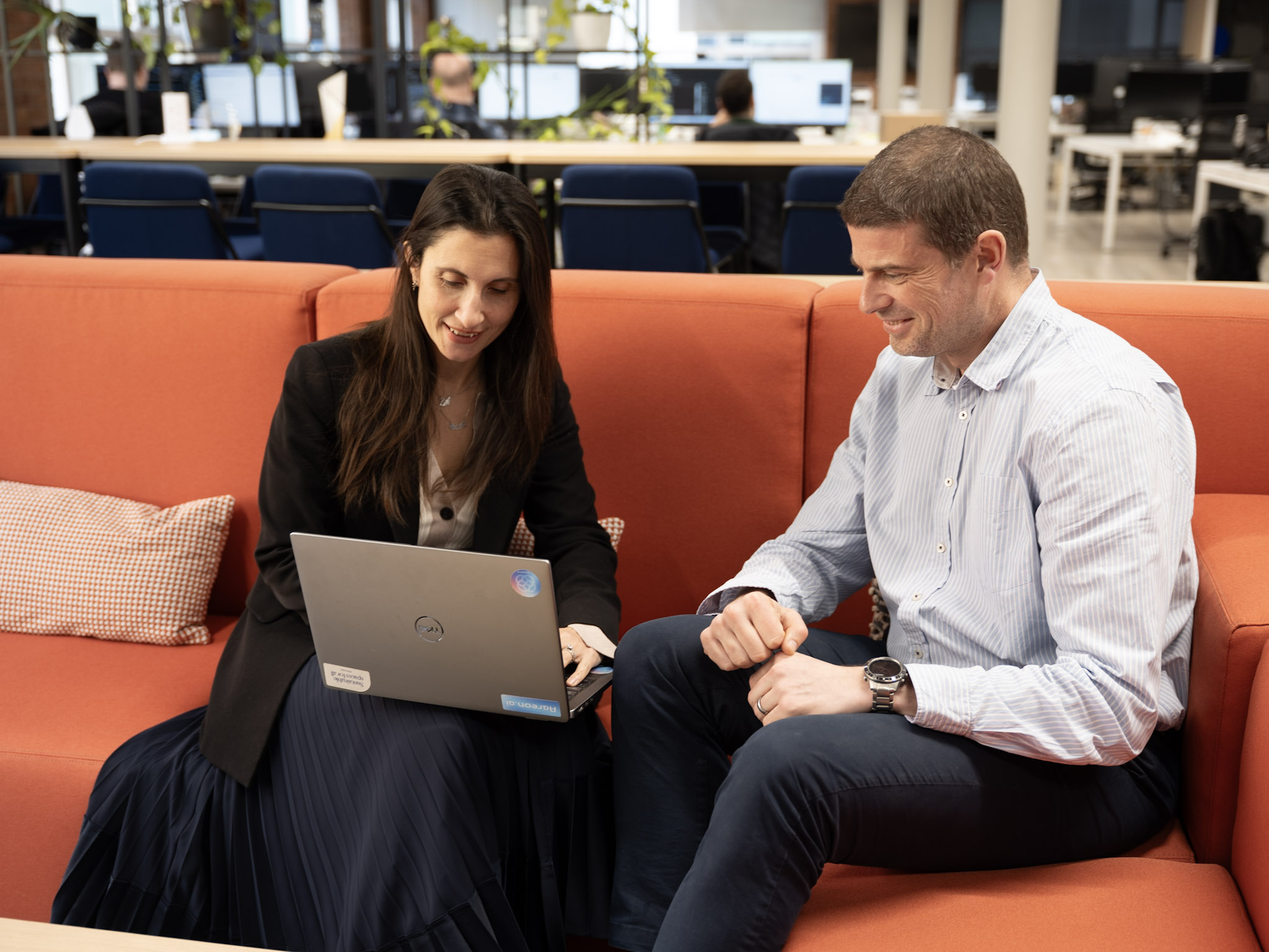 Two Aareon colleagues reviewing work together on a laptop in an office