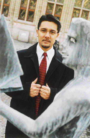 Aarij Khan standing among stone figures at KU Leuven in 2003