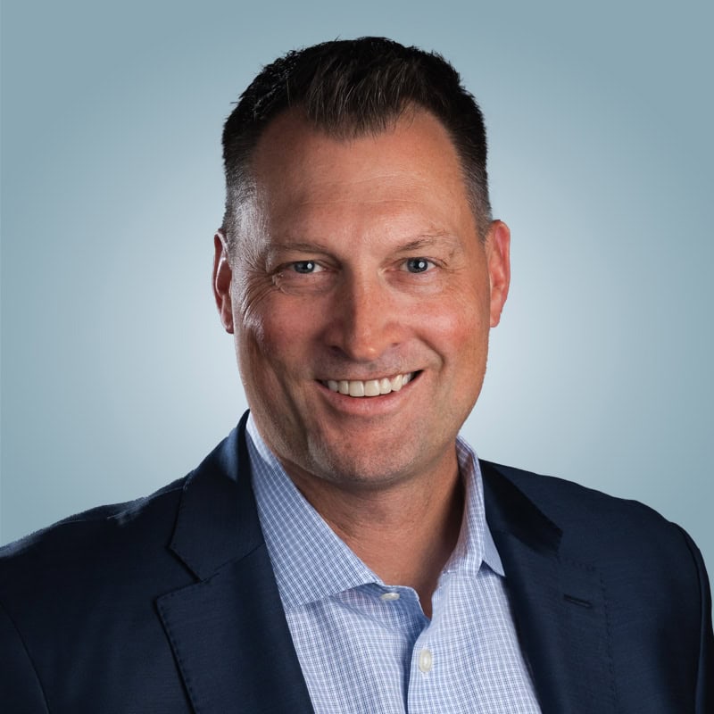 Aaron Brodt in a dark jacket and open-collar shirt