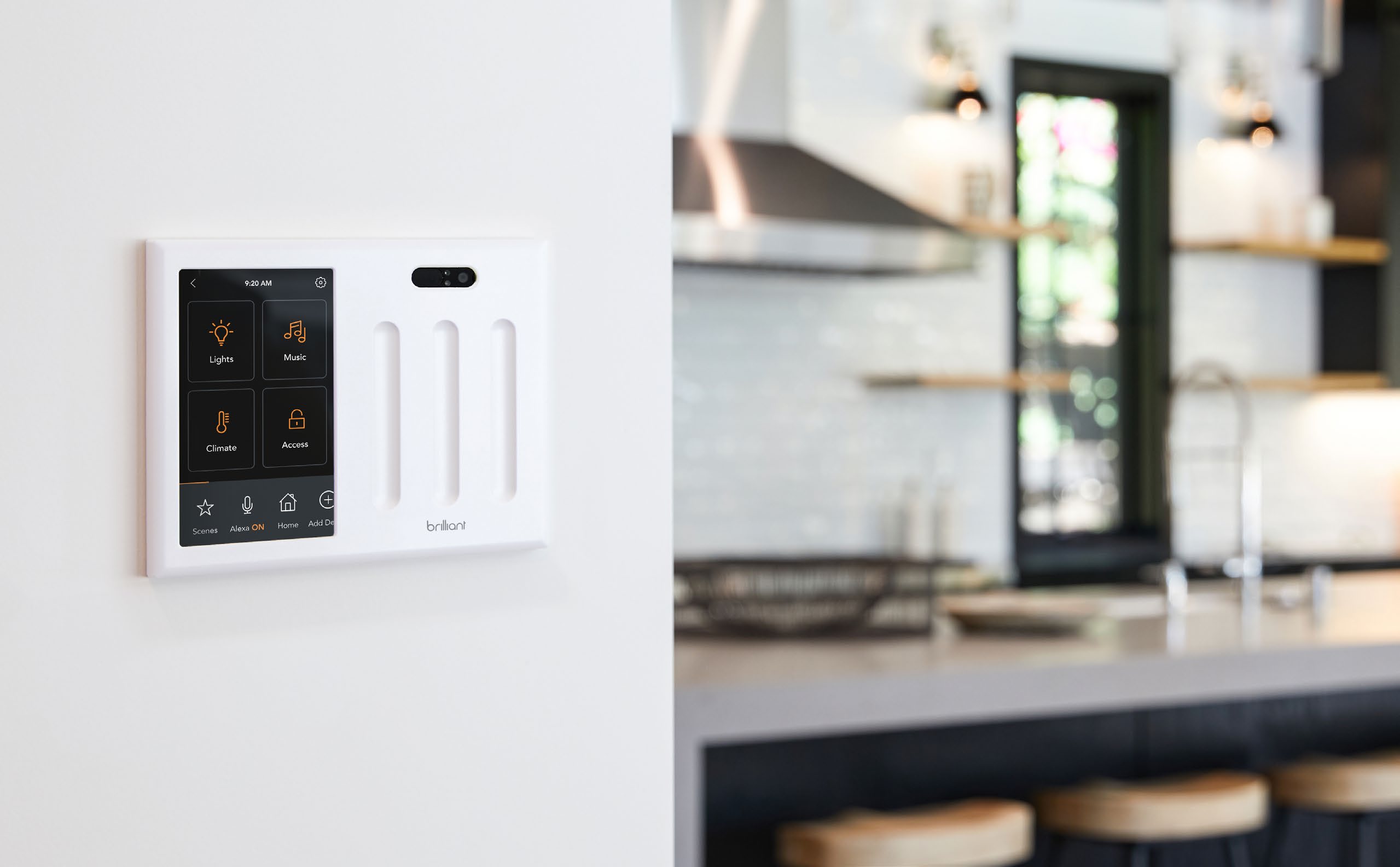A Brilliant touchscreen control and three lighting sliders installed on a kitchen wall