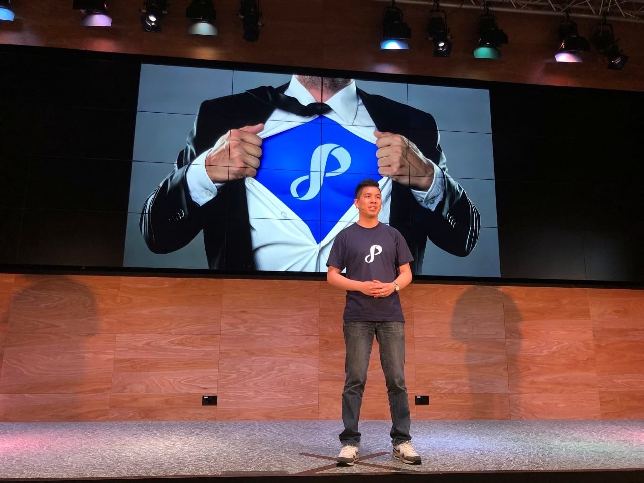 Aaron Lim presenting on stage wearing a Privyr T-shirt
