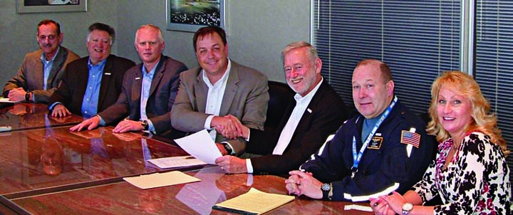 Aaron Todd, fourth from left, shakes hands with OPEIU president Michael Goodwin at the February 2012 contract signing.