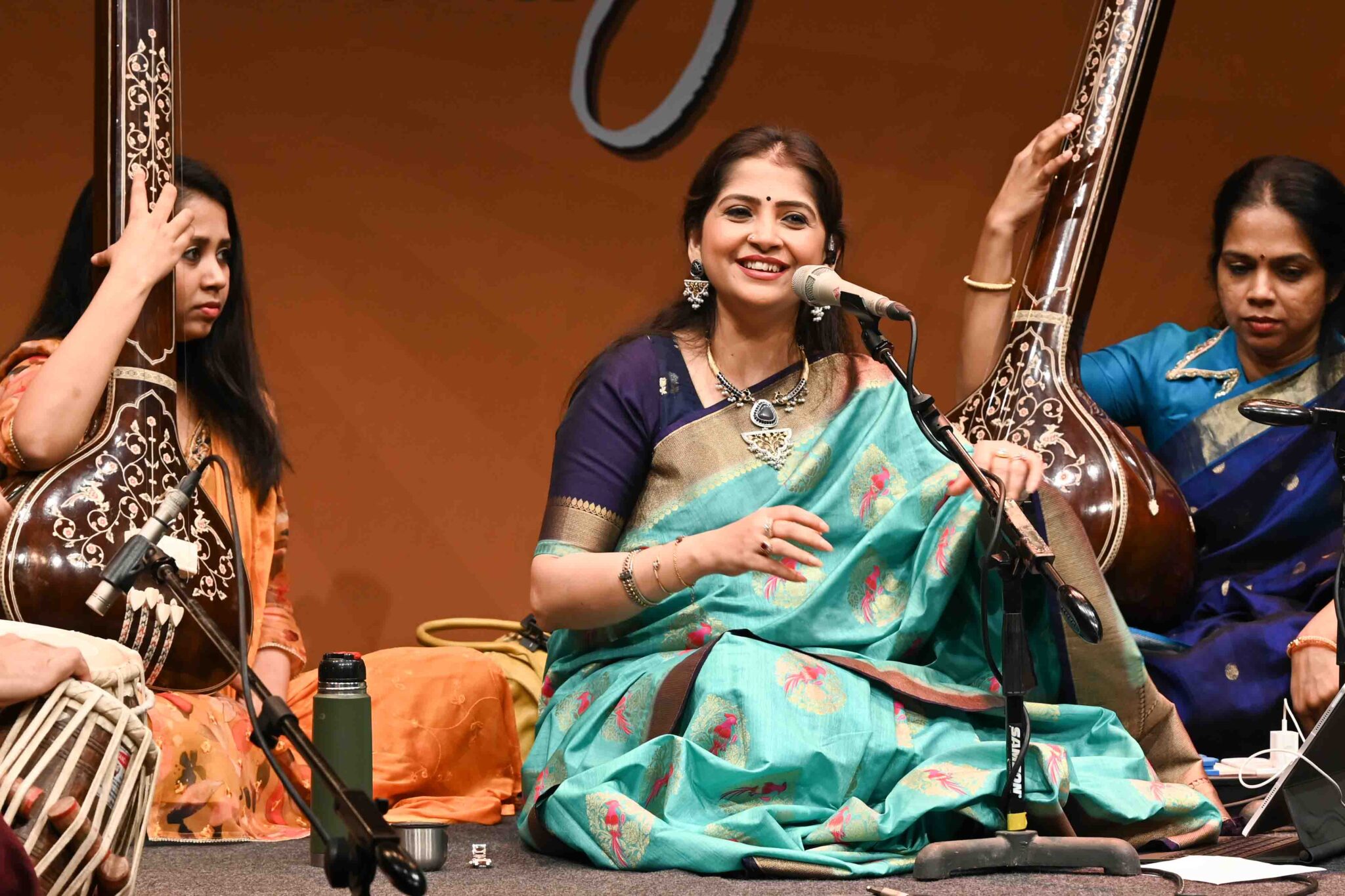 A Hindustani classical vocalist performing with accompanying musicians and tanpuras