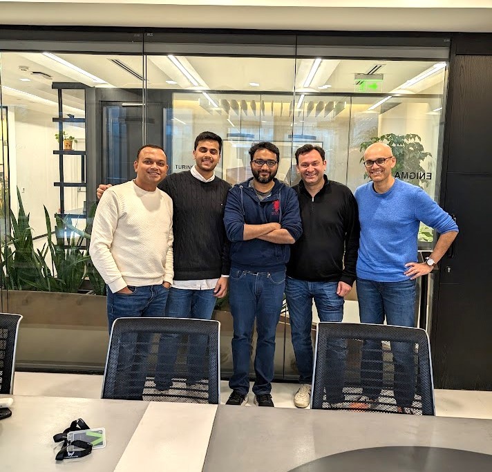 Aayush Ghosh Choudhury, at center, standing with four colleagues in a glass-walled office