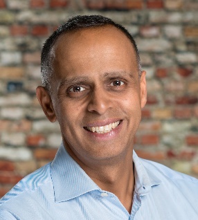 Abacus Insights founder and CEO Minal Patel smiling in front of a brick wall