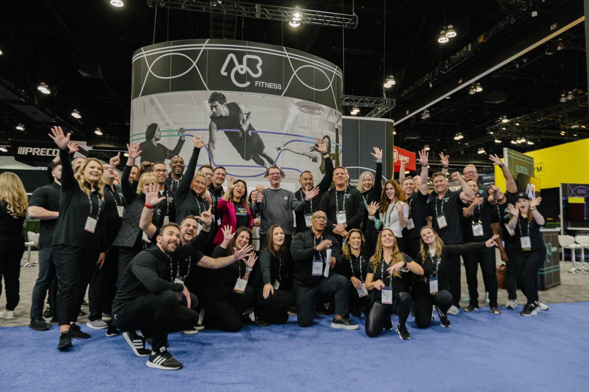 ABC Fitness team members gathered at an industry trade show booth