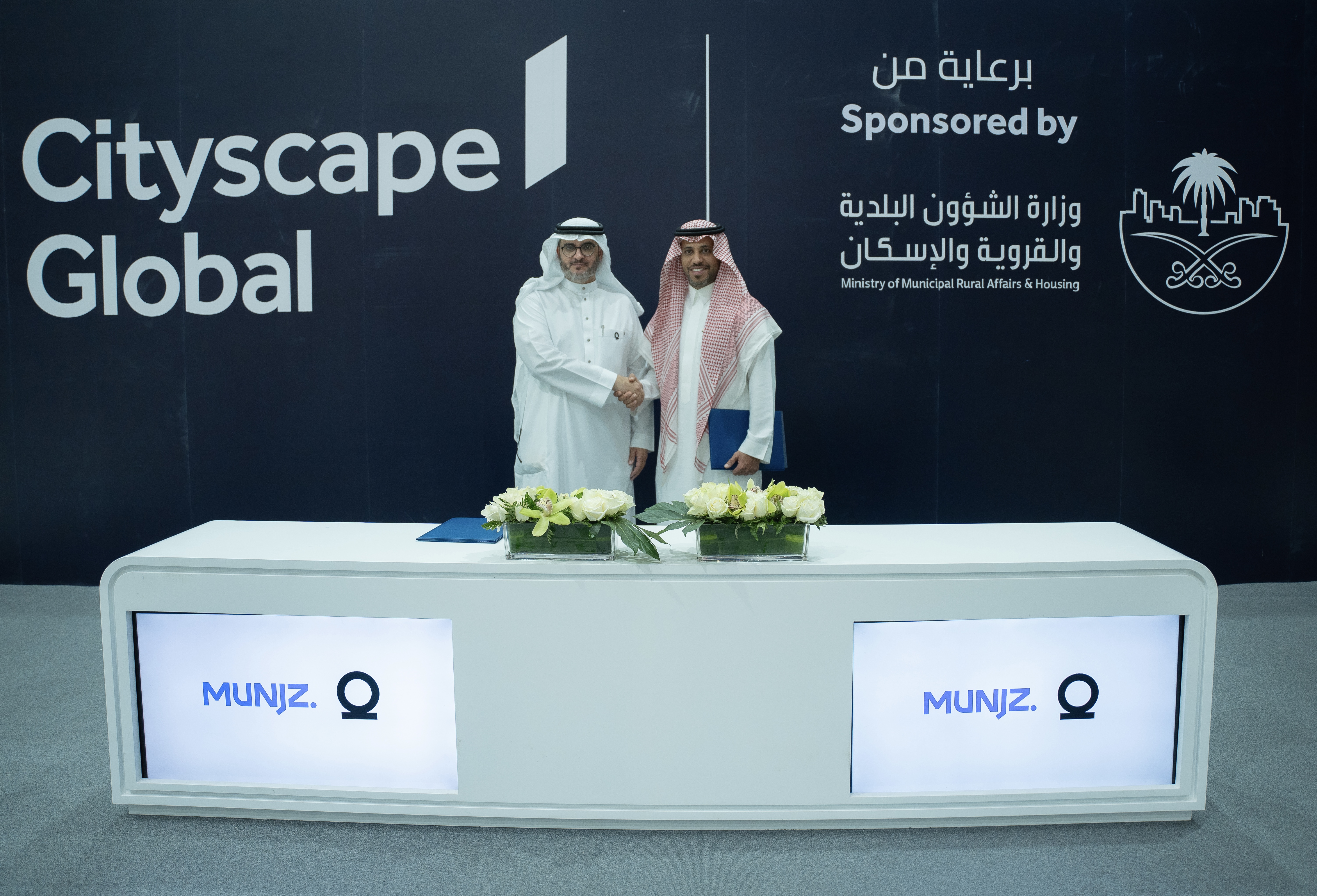 Munjz representatives shake hands at a Cityscape Global partnership signing in September 2023