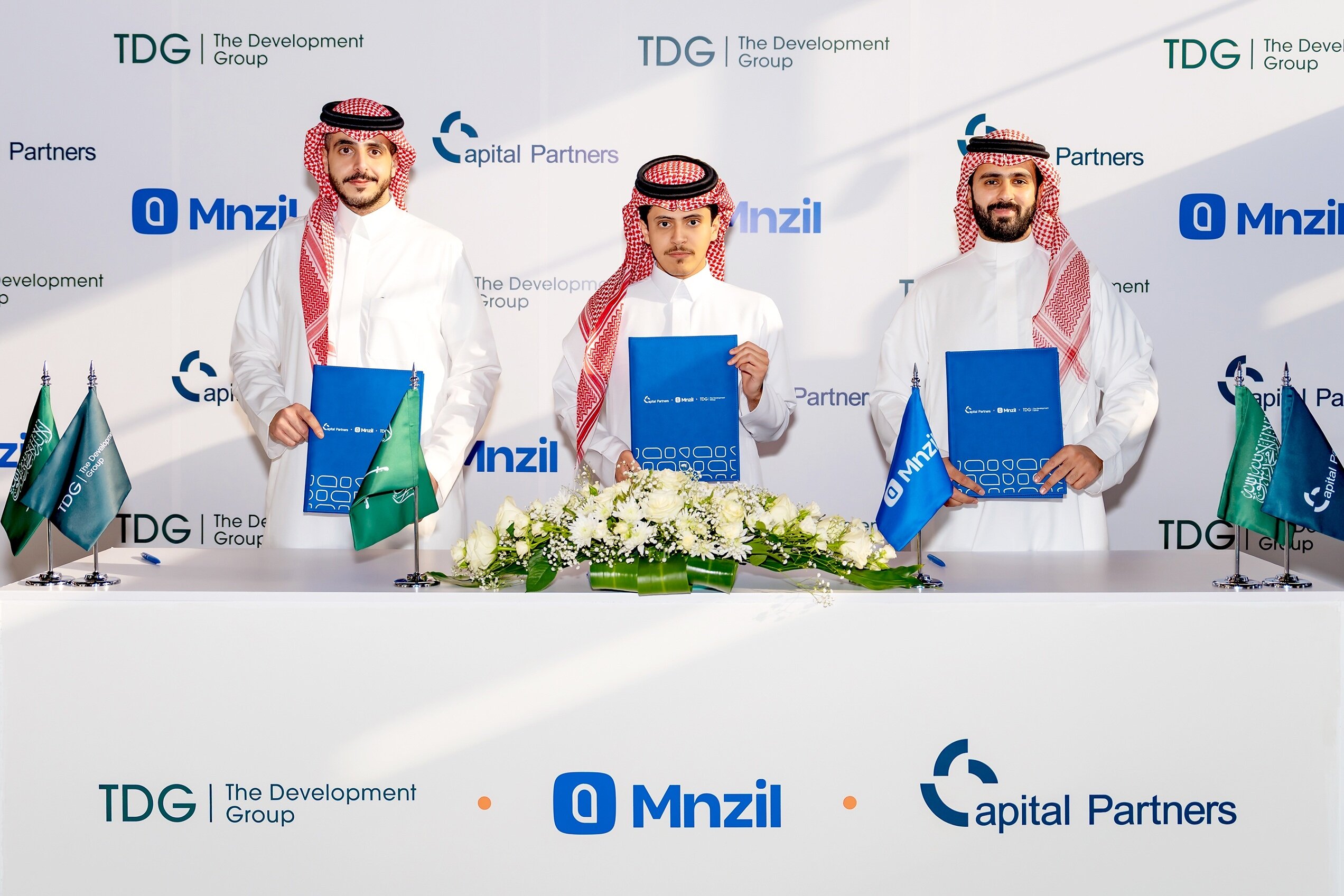 Talal Raqaban, Majeed Albabtain and Saud Al Rajhi holding partnership documents at the workforce housing fund announcement