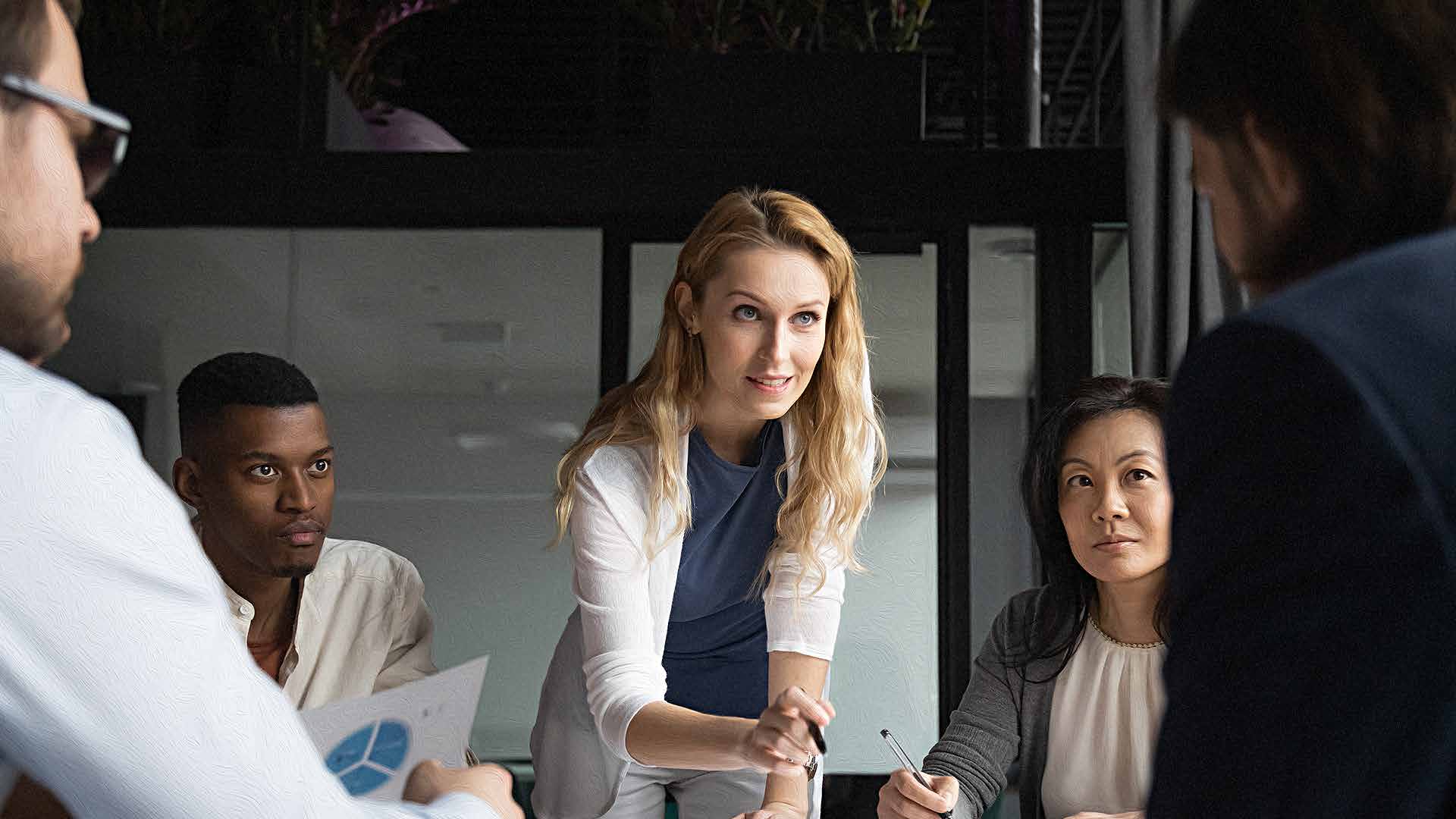 An illustrative photograph of colleagues discussing charts around a table