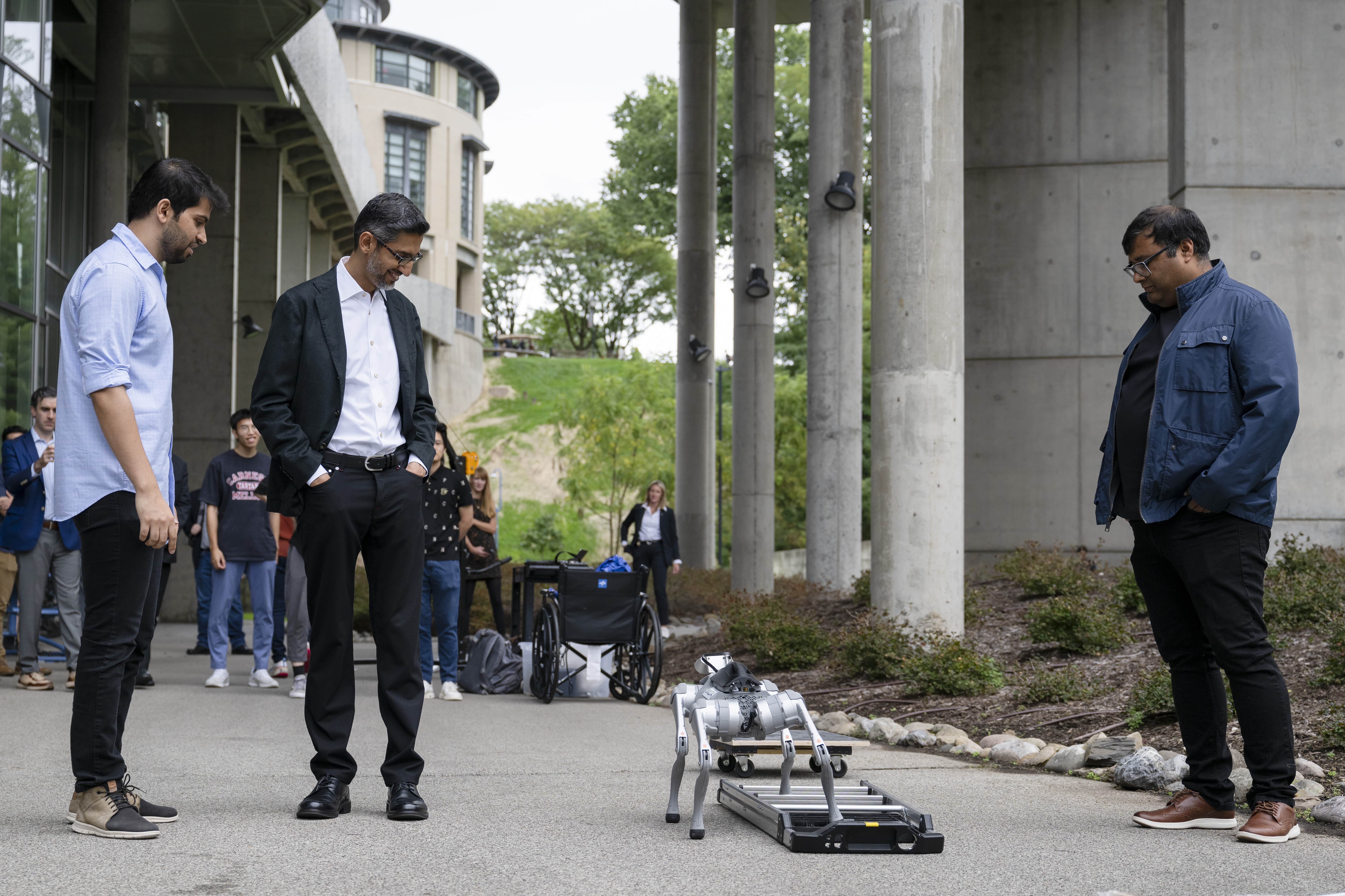 Deepak Pathak, Sundar Pichai and Abhinav Gupta watch a quadruped robot cross uneven terrain at Carnegie Mellon
