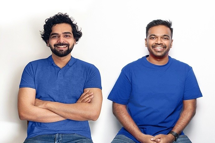 BukuWarung co-founders Chinmay Chauhan, left, and Abhinay Peddisetty, right, seated together in blue shirts