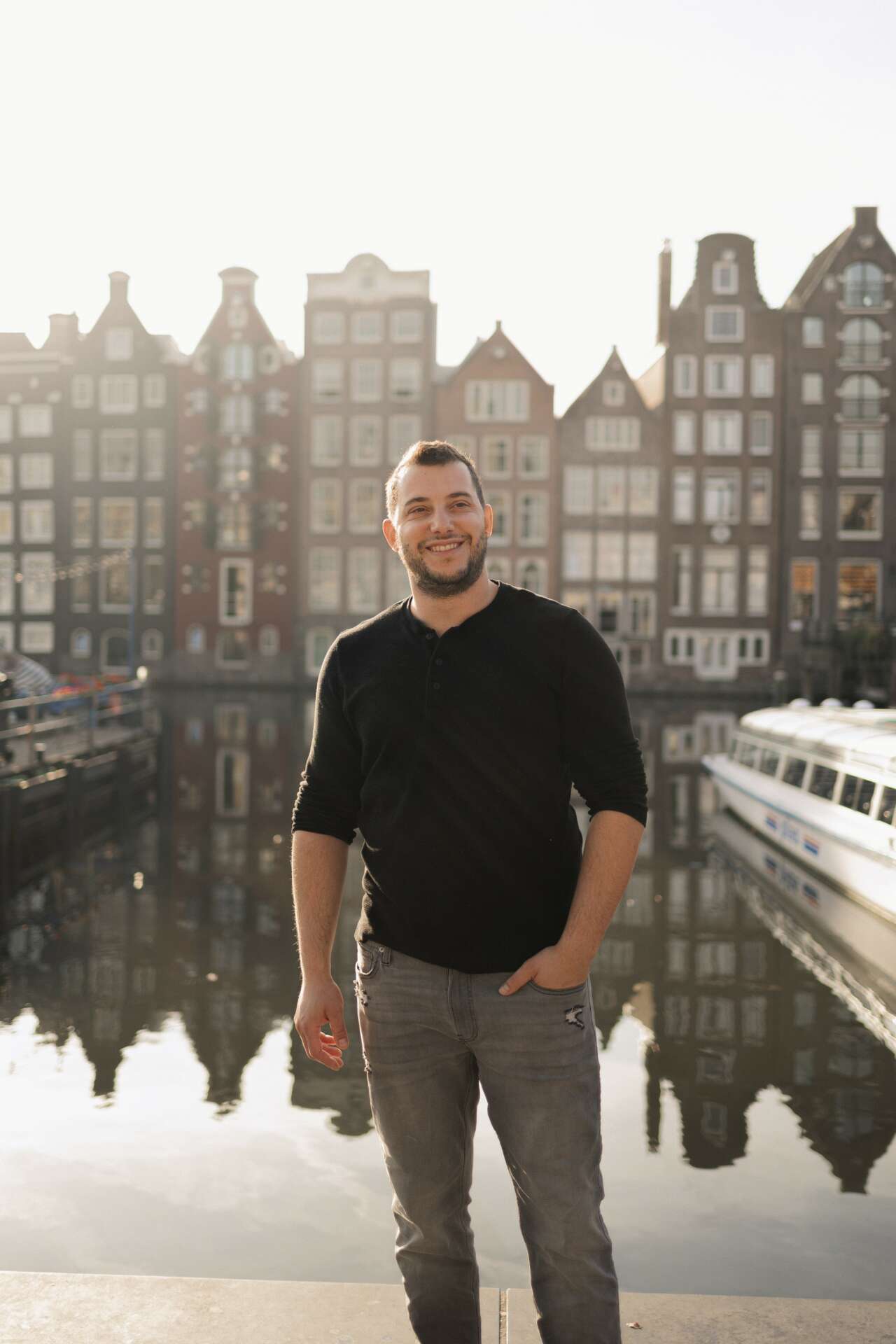AB Lieberman standing beside an Amsterdam canal, with canal houses behind him