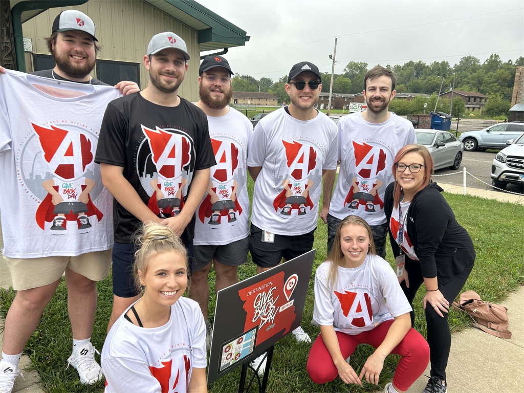 Abstrakt employees in Give Back Day shirts posing together outdoors in 2023