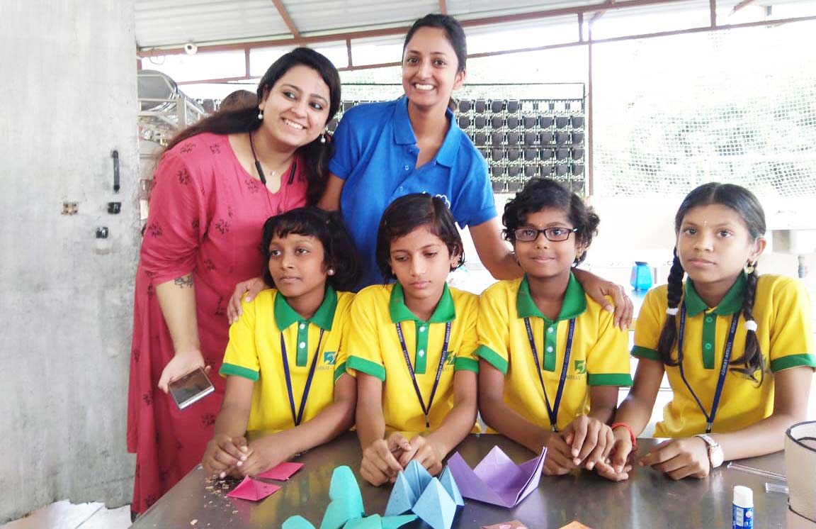 ABSYZ community volunteers and children gathered around paper crafts