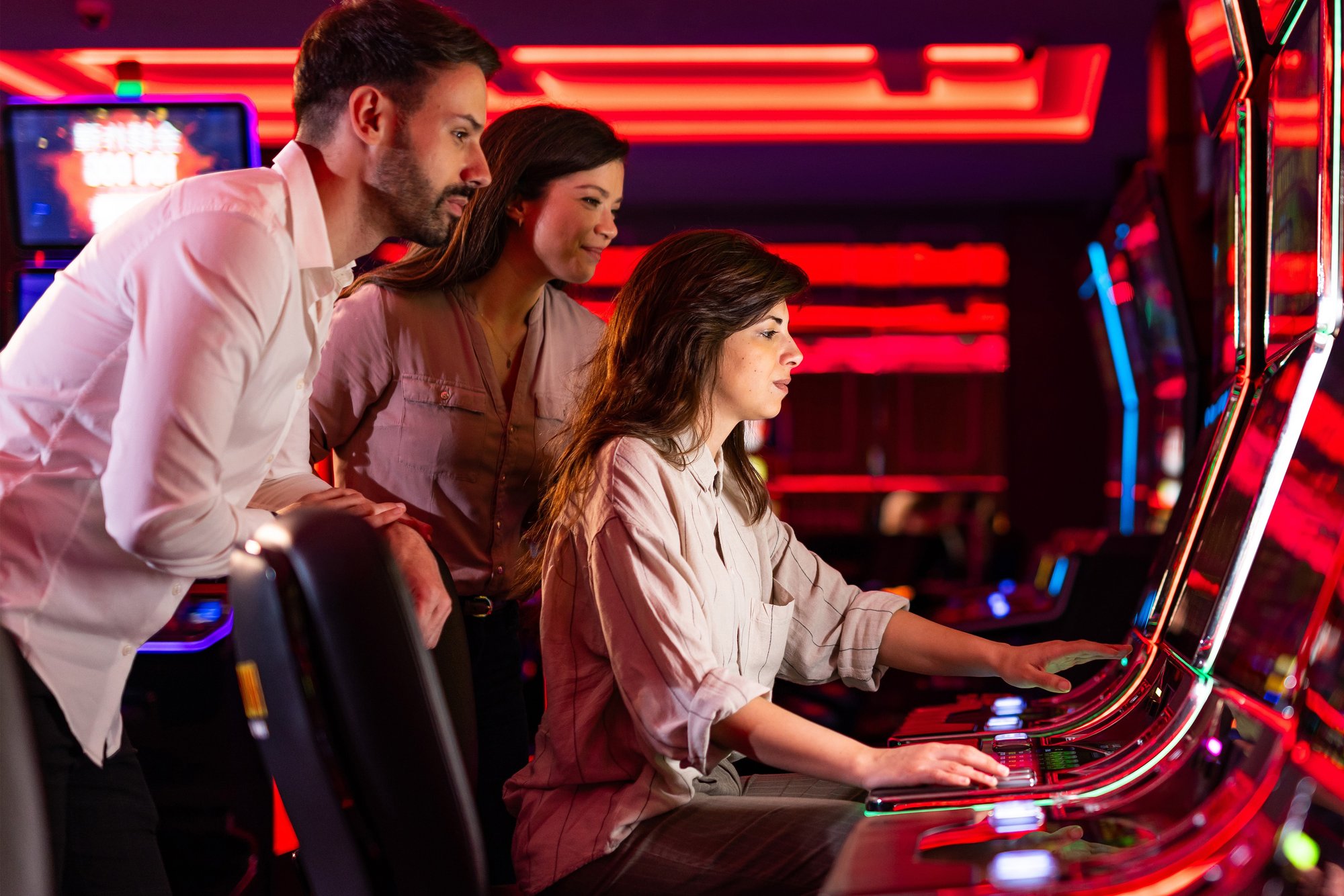 Three adults gathered around illuminated gaming terminals in an Accel promotional photograph