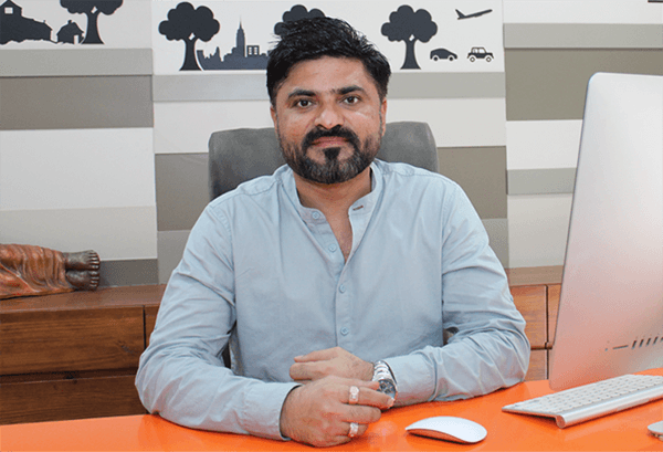 Acquaint Softtech founder and CEO Mukesh Ram seated at his desk