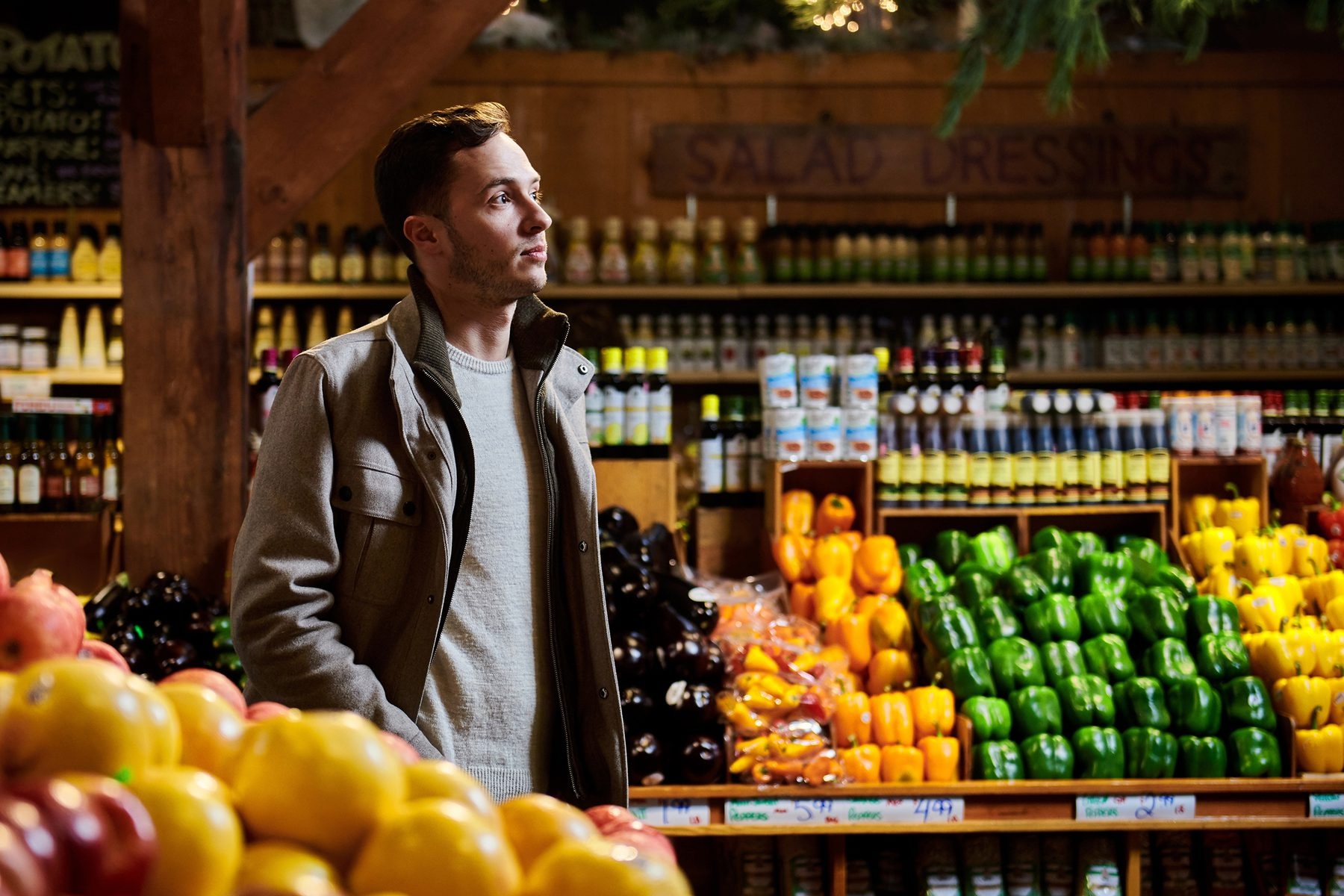 Adam Behrens standing among peppers and other produce in a food market