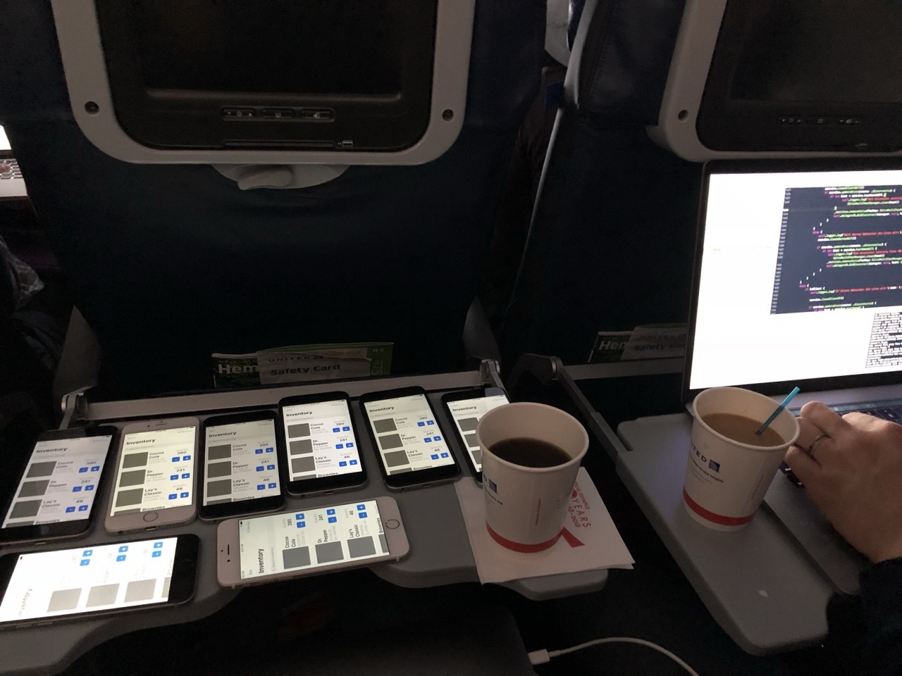 Multiple phones and a laptop testing an early Ditto inventory prototype on an airplane tray table