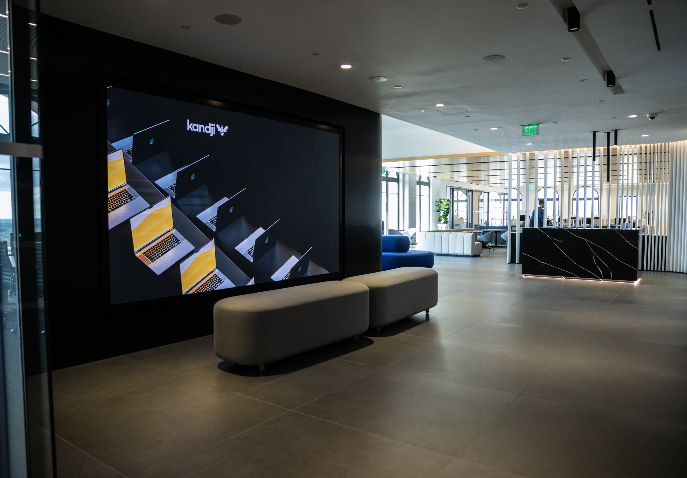 Kandji’s Coral Gables office, with a display of Apple laptops and its former logo