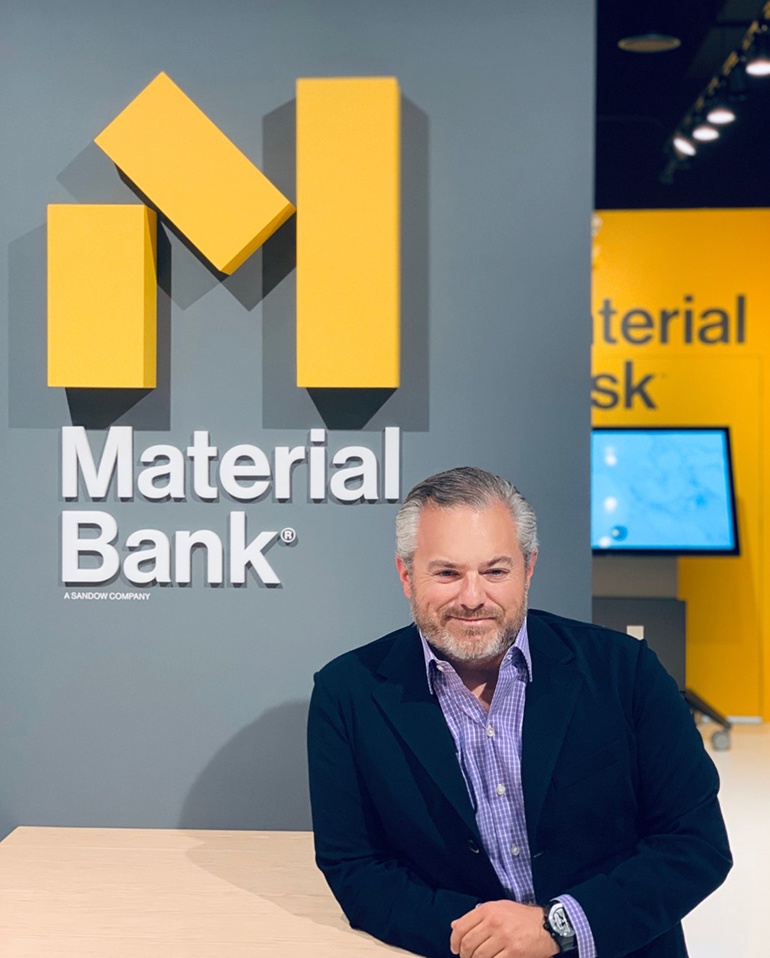 Adam Sandow seated beside Material Bank signage at its design-industry launch period