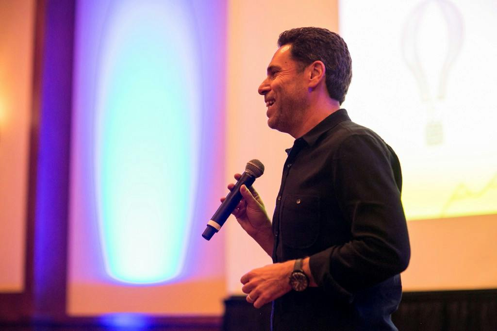 Adam Schwartz speaking with a handheld microphone at an Articulate retreat