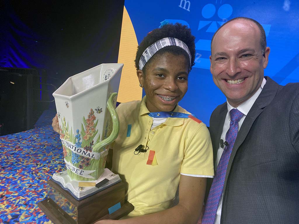 Adam Symson taking an onstage selfie with Scripps National Spelling Bee champion Zaila Avant-garde