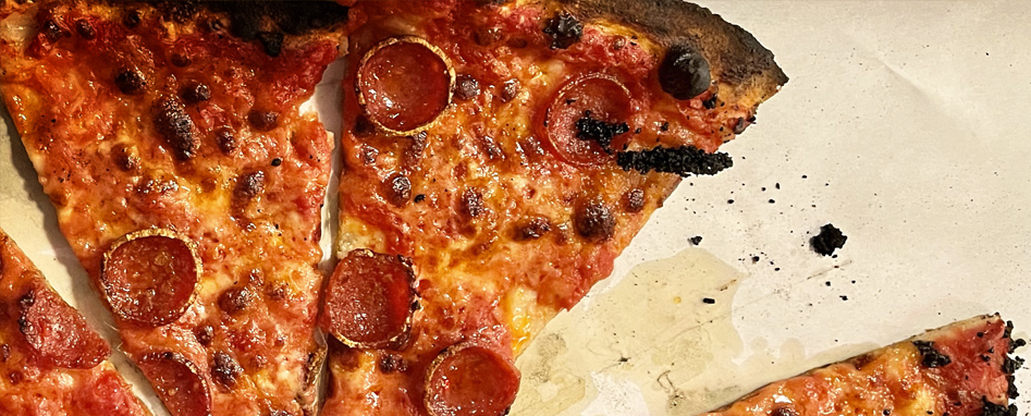 Close view of charred thin-crust pepperoni pizza used in Adams and Knight's Connecticut tourism work