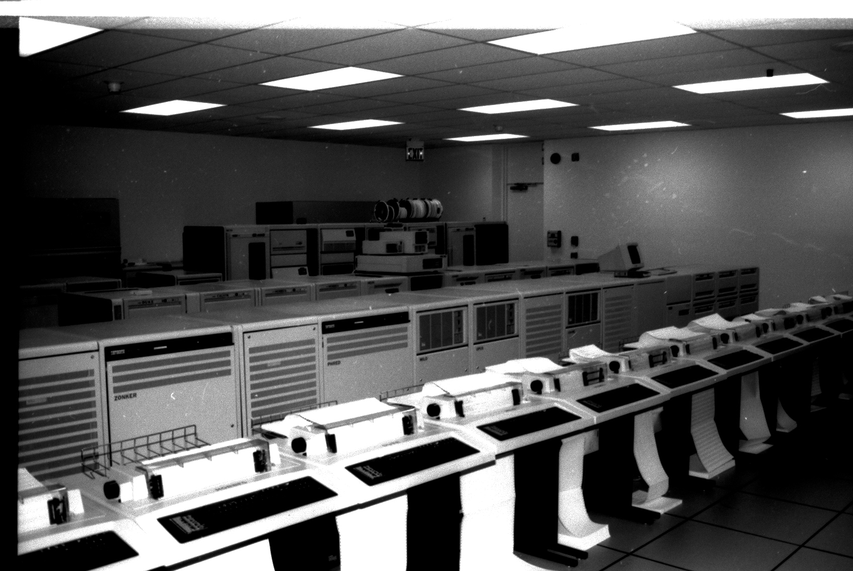 Archival black-and-white photograph of ADD’s computer room with rows of equipment and paper output