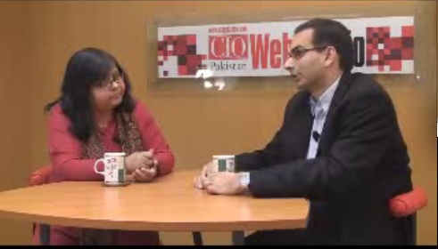 Jehan Ara, left, interviewing Adnan Lawai across a table for In the Line of Wire