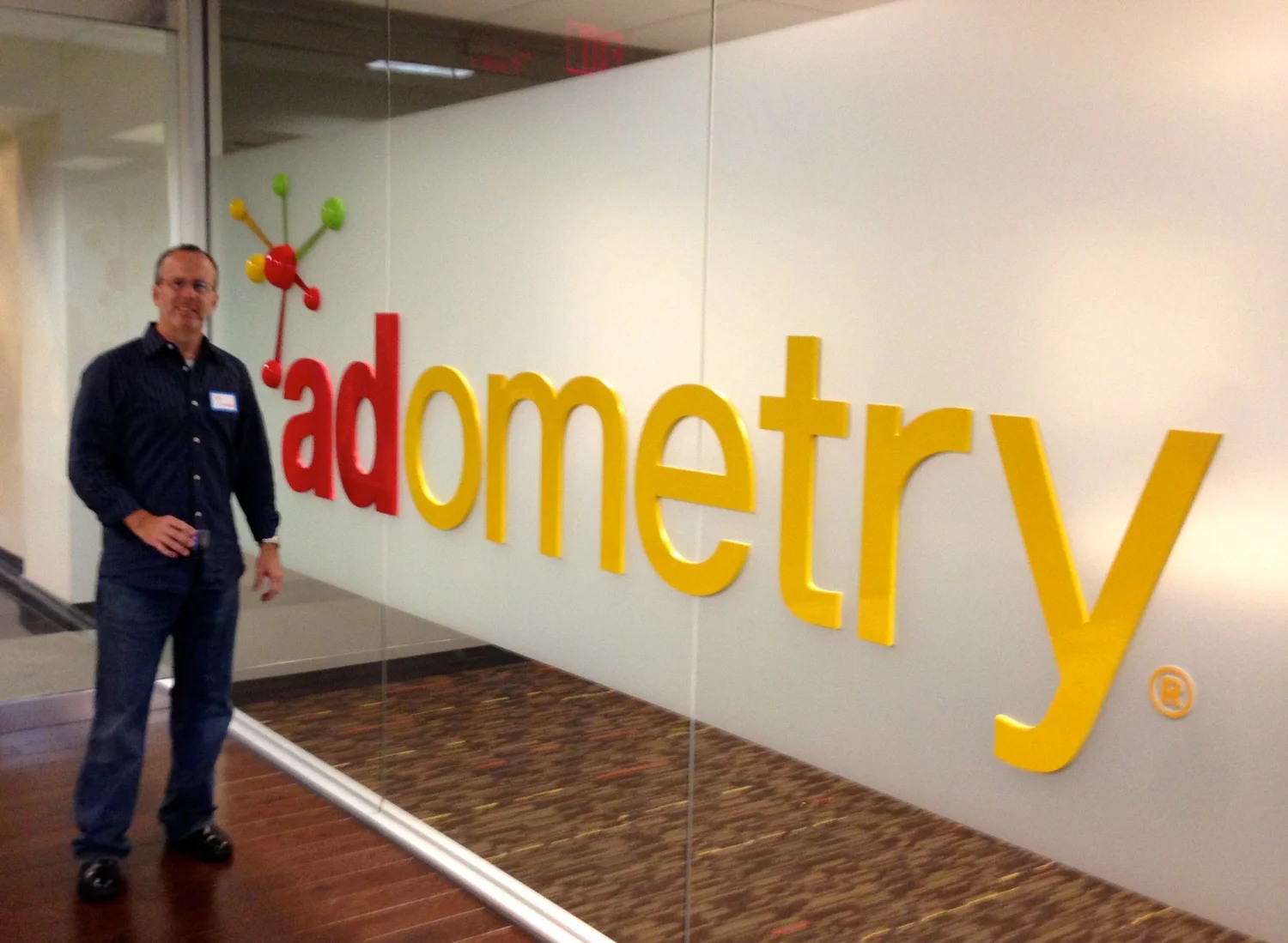Click Forensics co-founder Tom Cuthbert standing beside the Adometry office sign