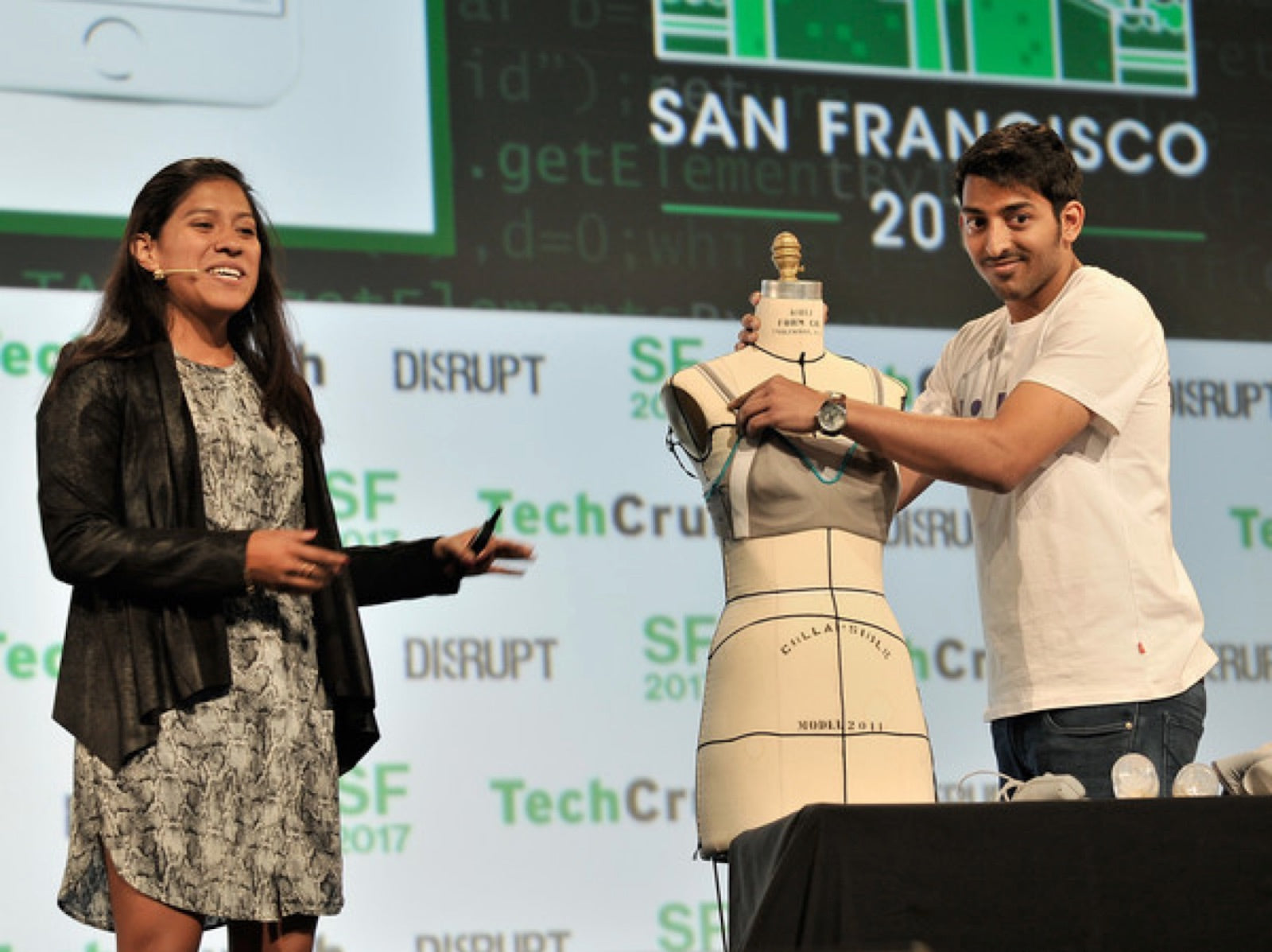 Adriana presenting on the TechCrunch Disrupt stage while Sujay demonstrates the team's hardware