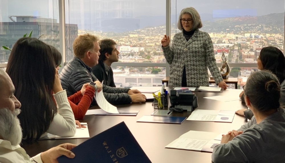 Susan Murphy speaking to a group seated around a conference table in Los Angeles