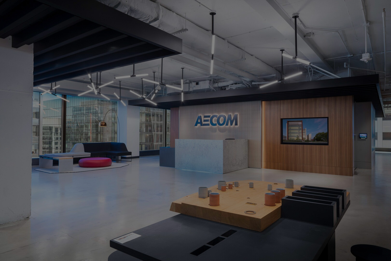 AECOM office interior with exposed ceiling services, seating and a reception desk