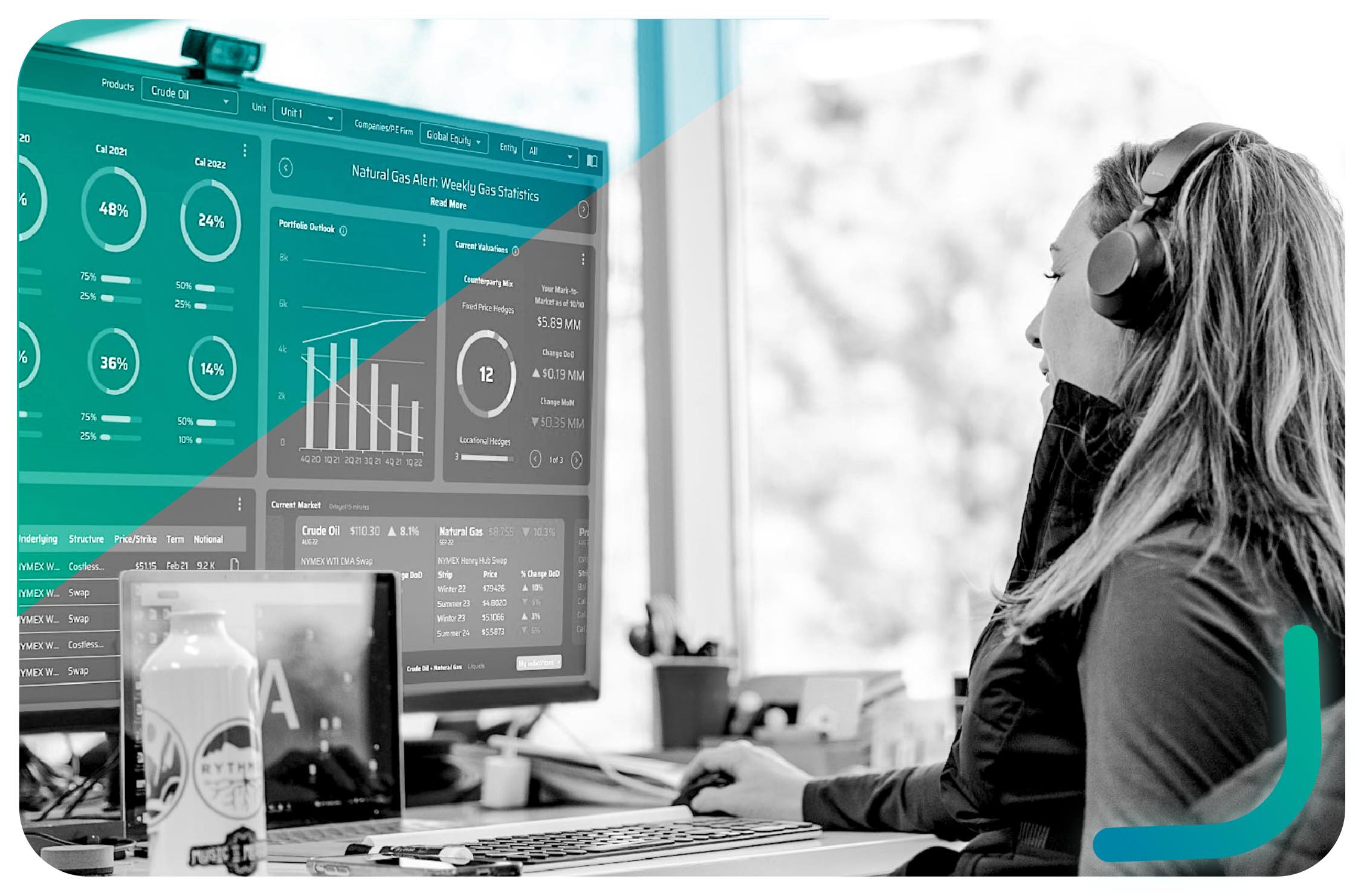 An AEGIS employee viewing commodity portfolio analytics on a large office monitor