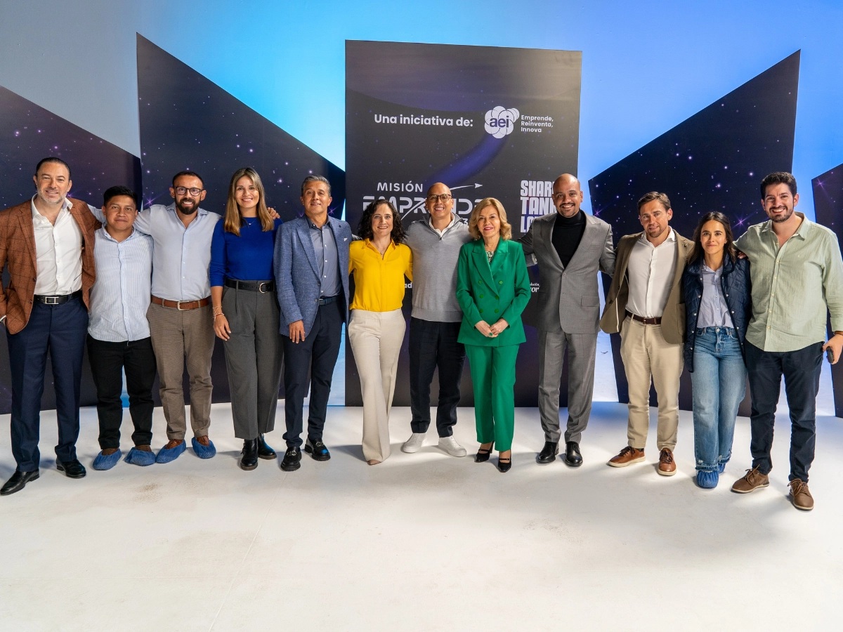 Group gathered in front of Misión Emprende 593 and Shark Tank Latam signage