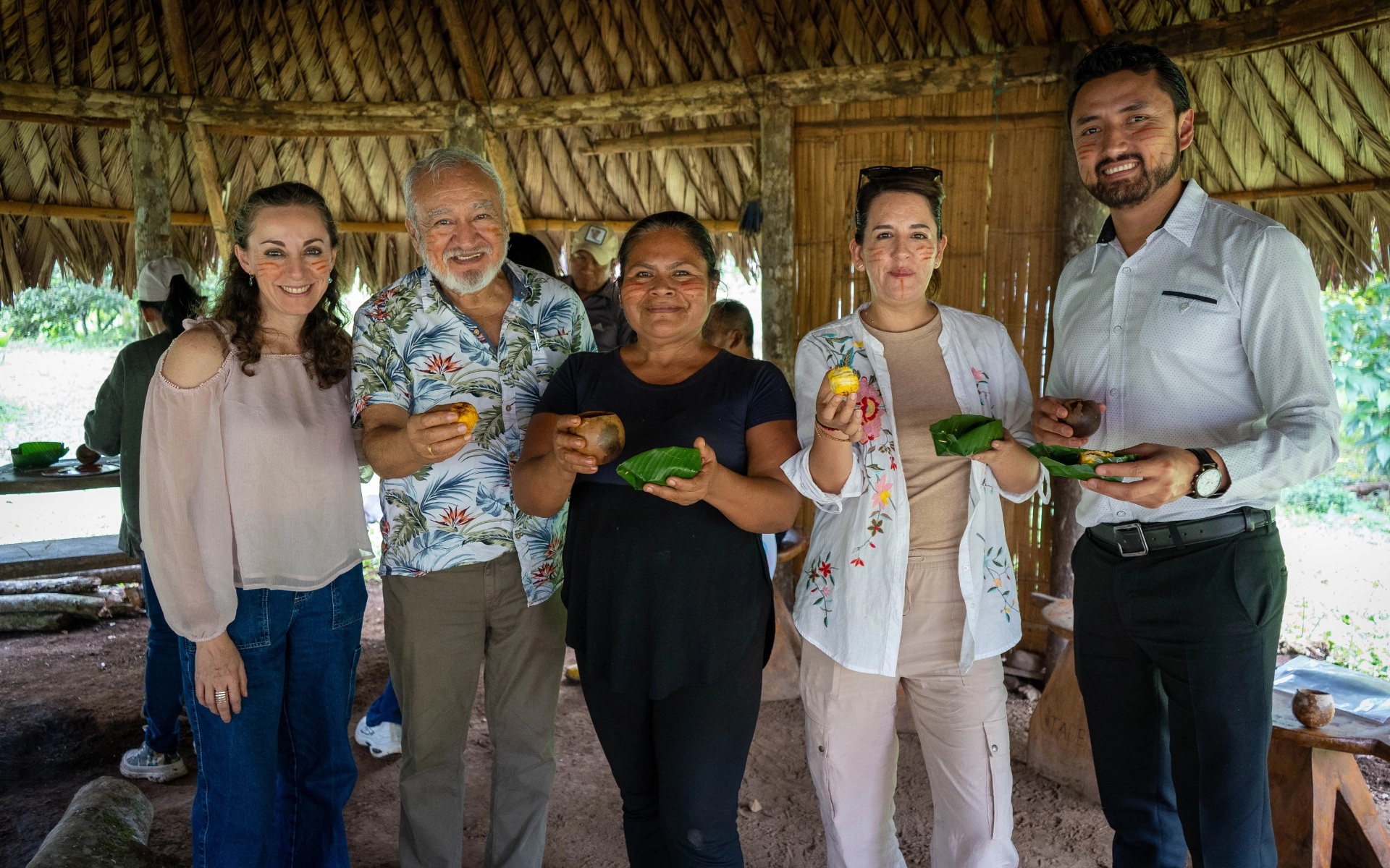 Five people share food during a field visit pictured on AEI’s about page