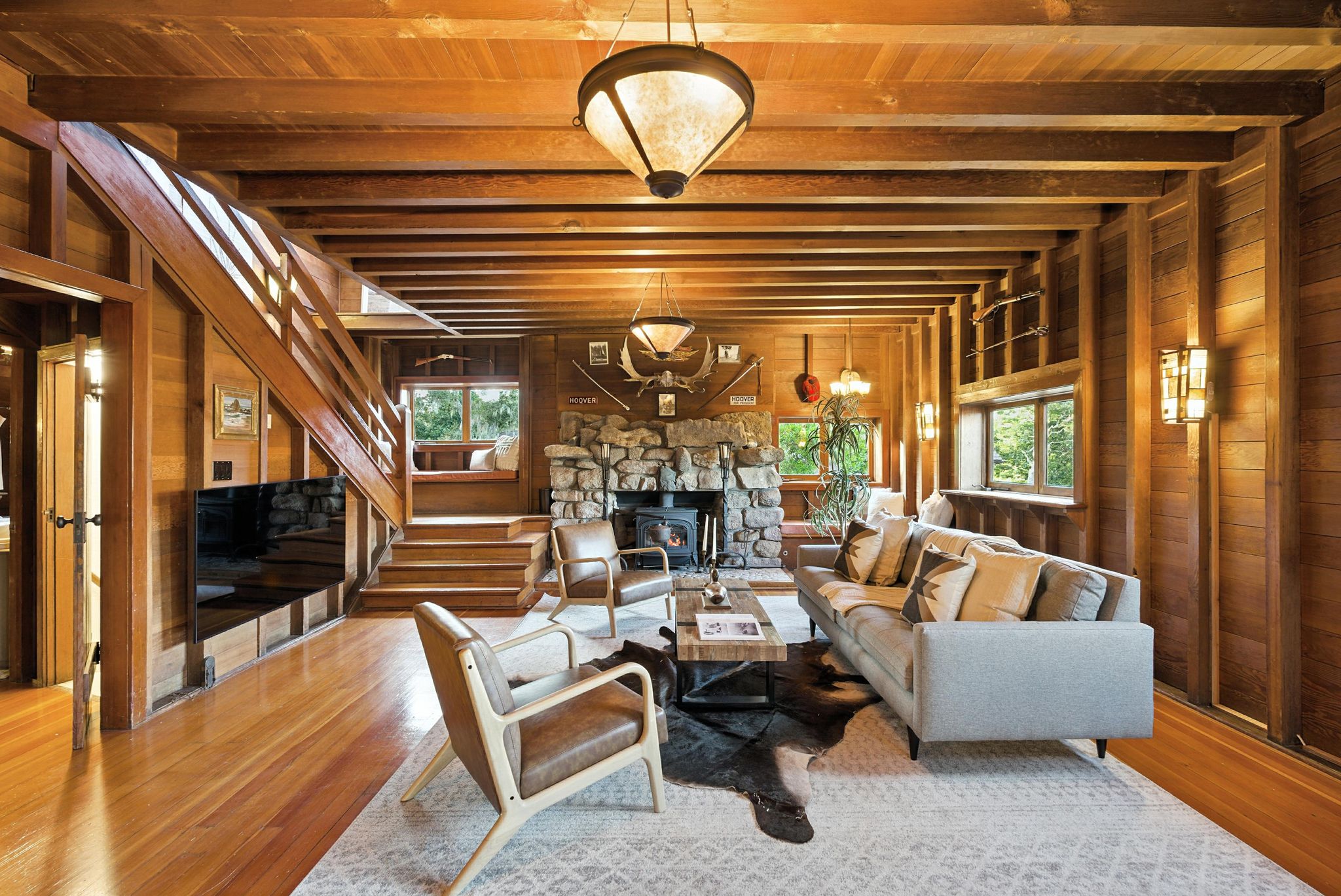 Wood-paneled living room of the Henry-Hoover House, with exposed beams and a stone fireplace