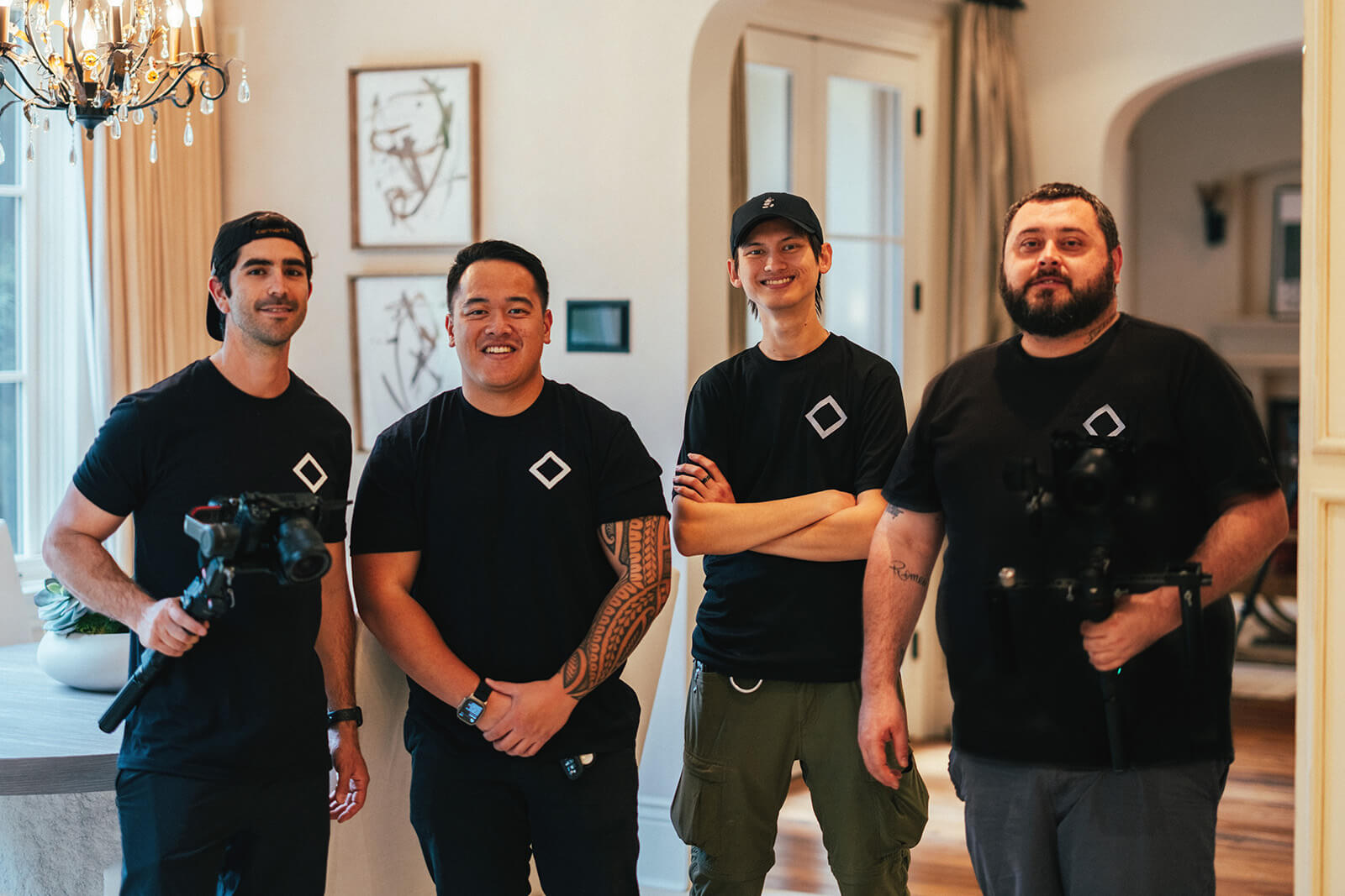 Four Aerial Canvas team members with camera equipment inside a home